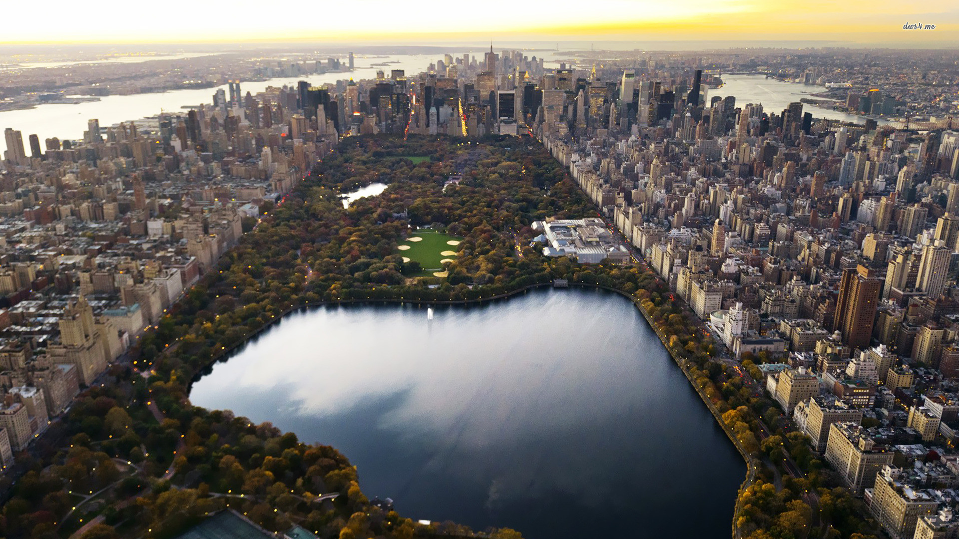 Aerial view of Central Park in New York City during sunset, surrounded by skyscrapers