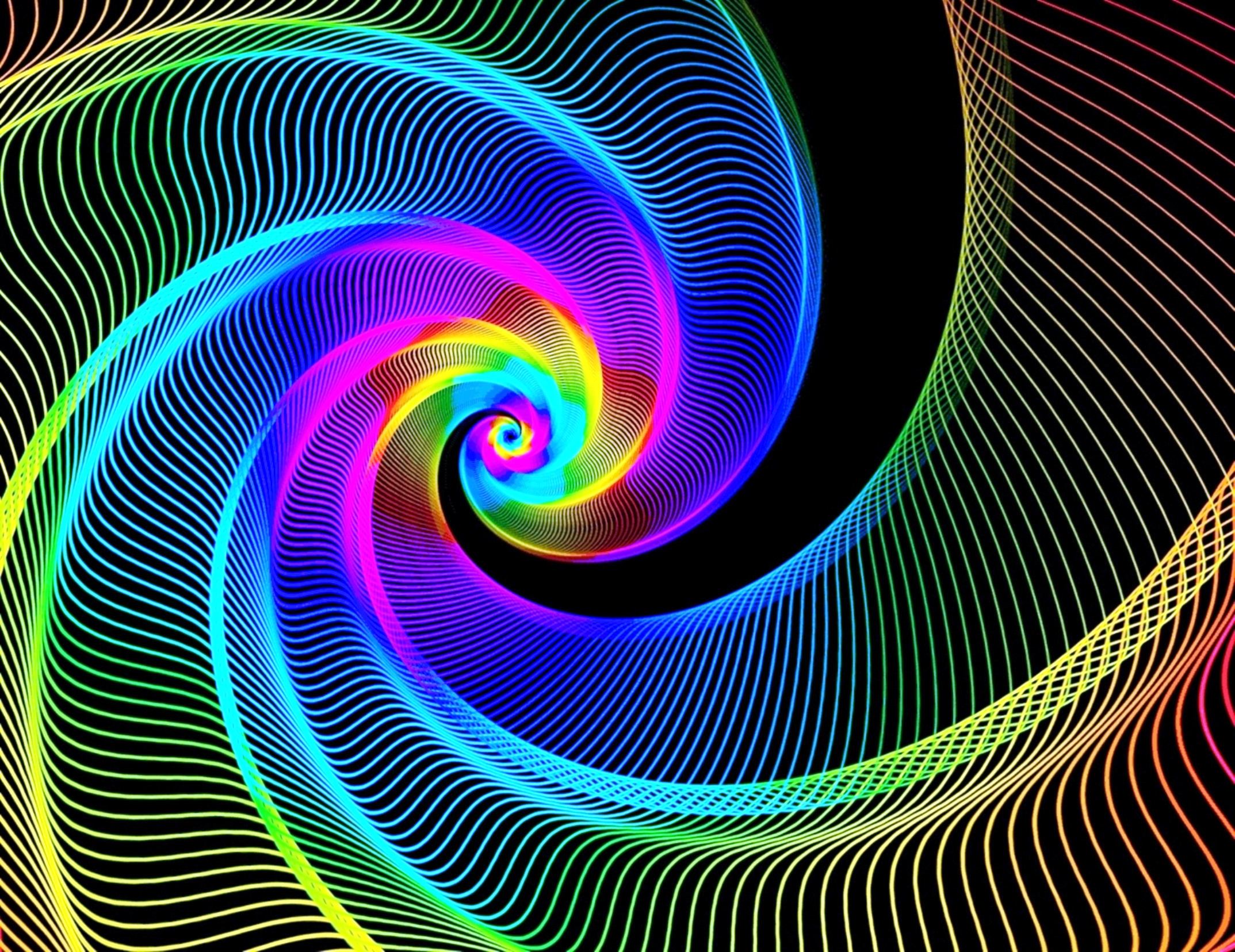 A vibrant, swirling abstract pattern of rainbow colors on a black background, resembling a digital vortex or a colorful spiral galaxy