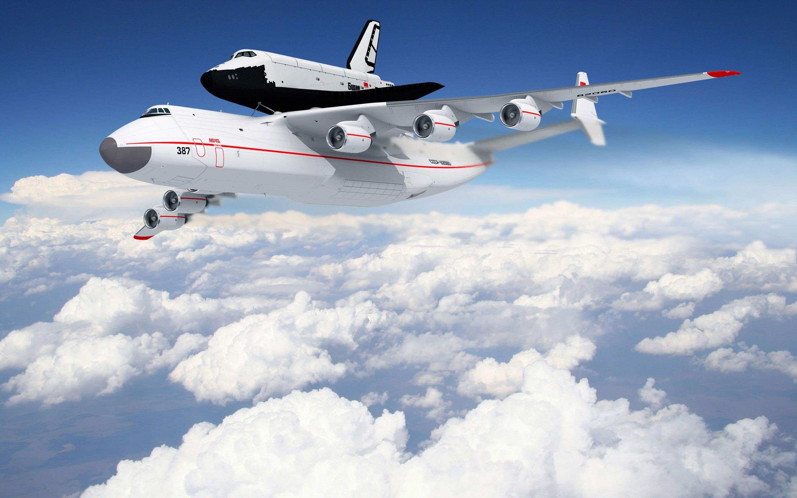 A white Antonov An-225 Mriya cargo aircraft carrying a space shuttle against a backdrop of a cloudy sky