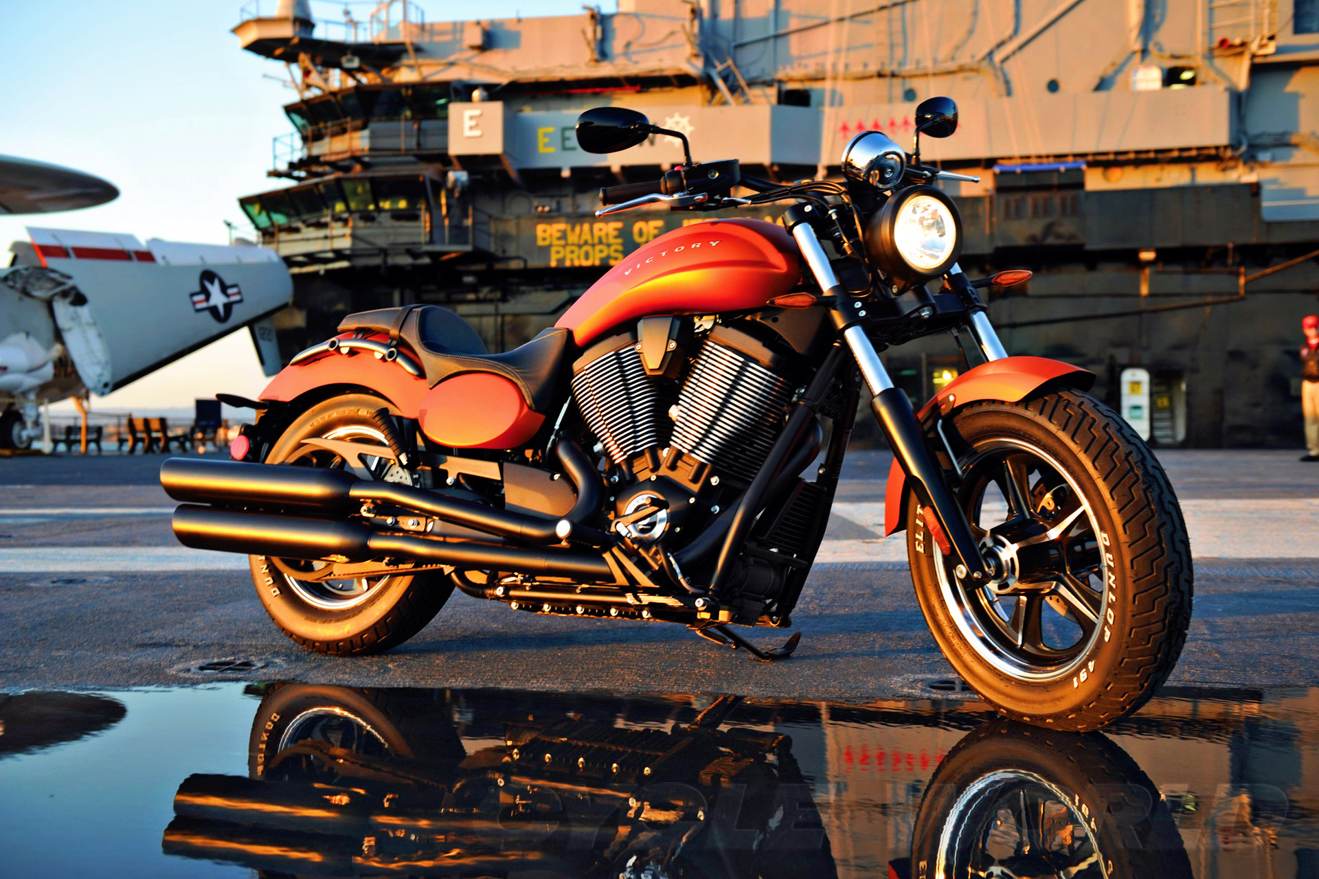 Victory Hammer 8-Ball Motorcycle parked on an aircraft carrier deck at sunset