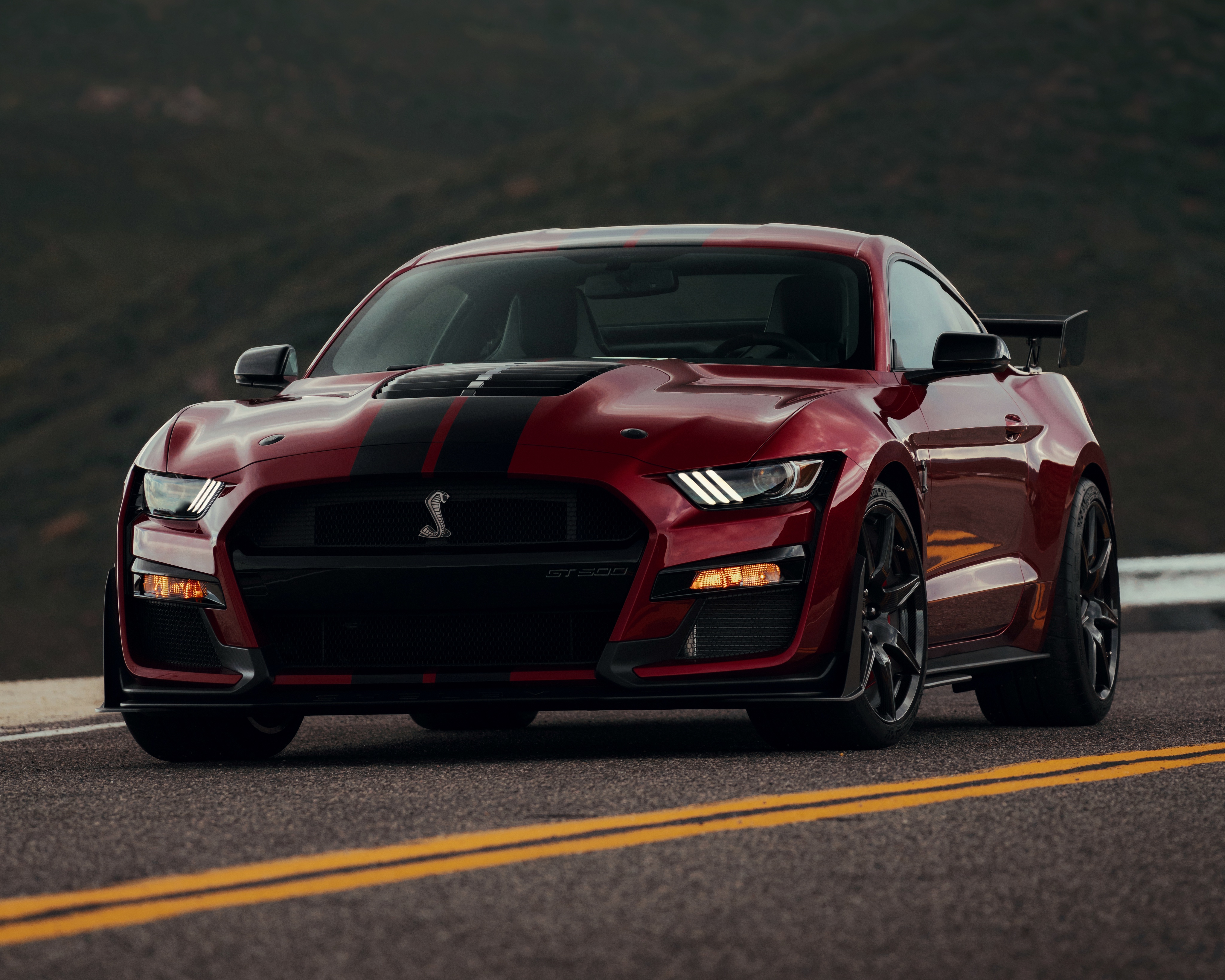 A red 2021 Ford Mustang Shelby GT500, parked on a mountain road