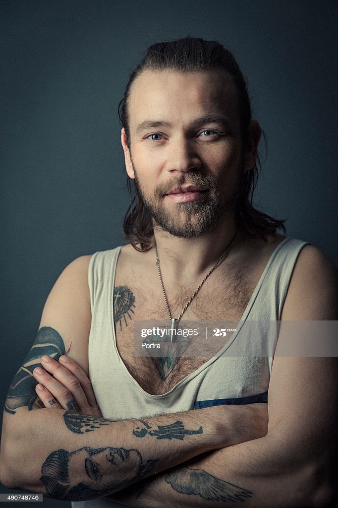 Free download Confident Tattooed Man With Arms Crossed Against Gray