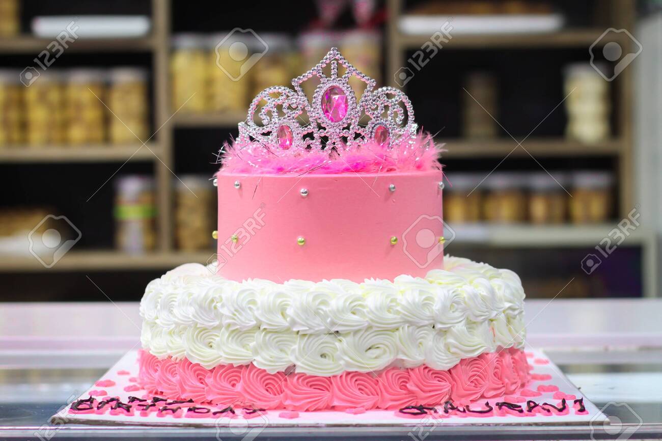 Pink Birthday Cake Decorated With Crown And Whipped Cream And