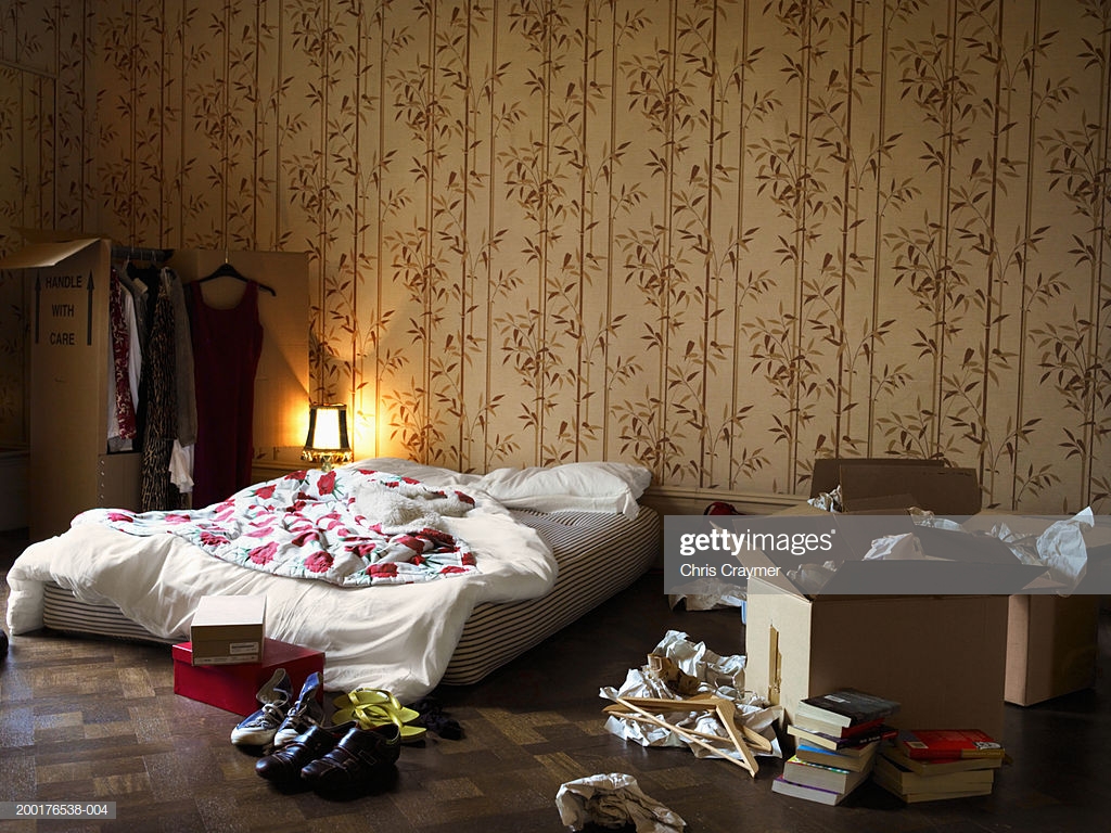 Bedroom With Mattress On Floor By Cardboard Boxes Stock Photo