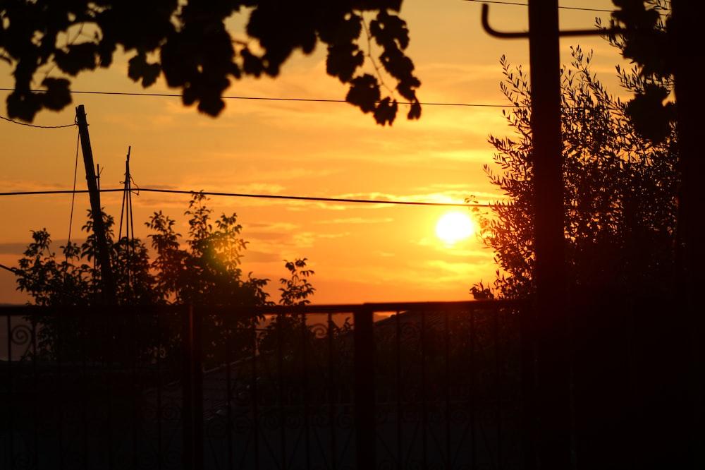 The Sun Is Setting Behind A Wire Fence Photo Albania Image