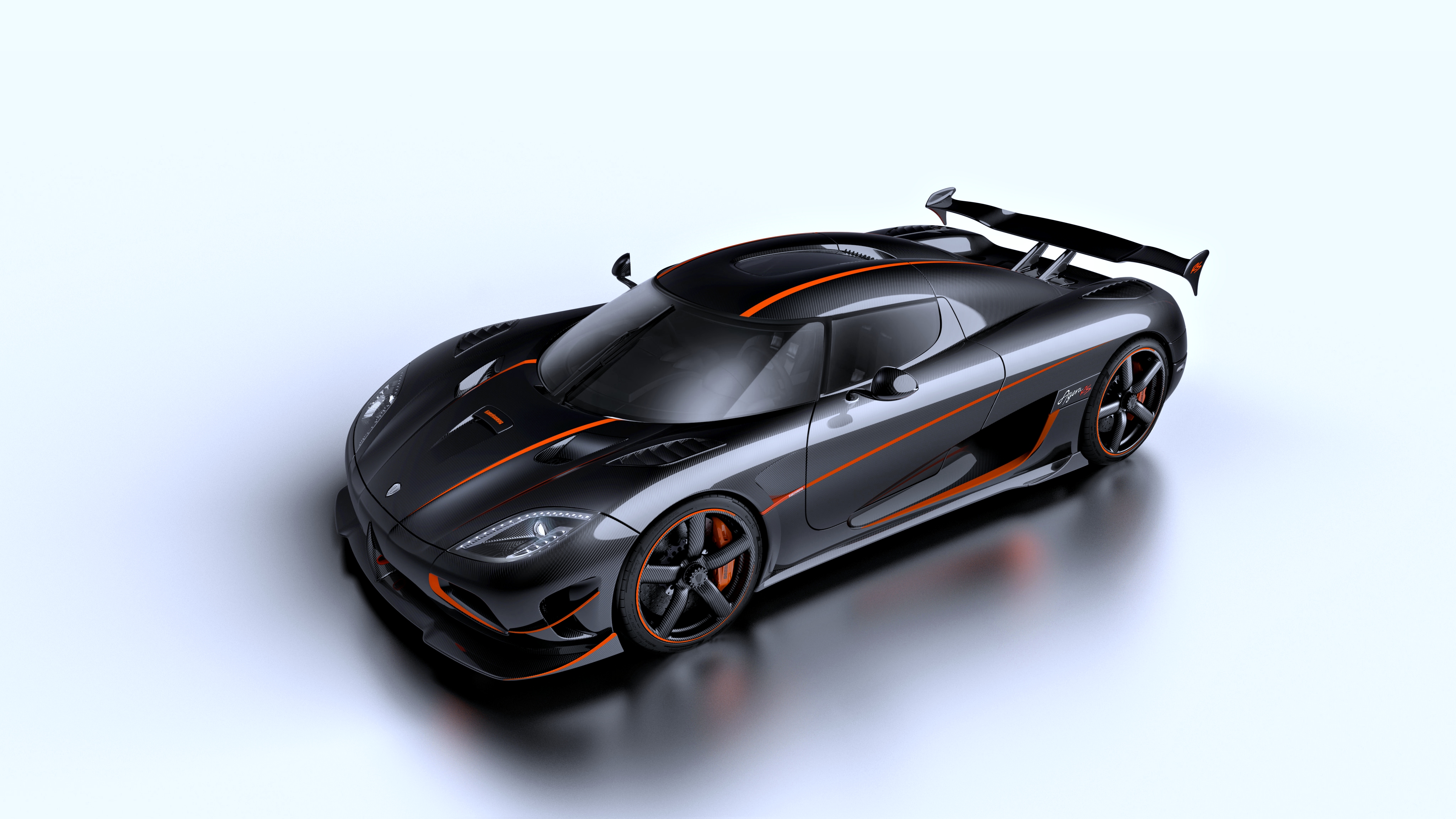 A sleek black Koenigsegg sports car with orange accents, shown from an angled perspective on a light gray background
