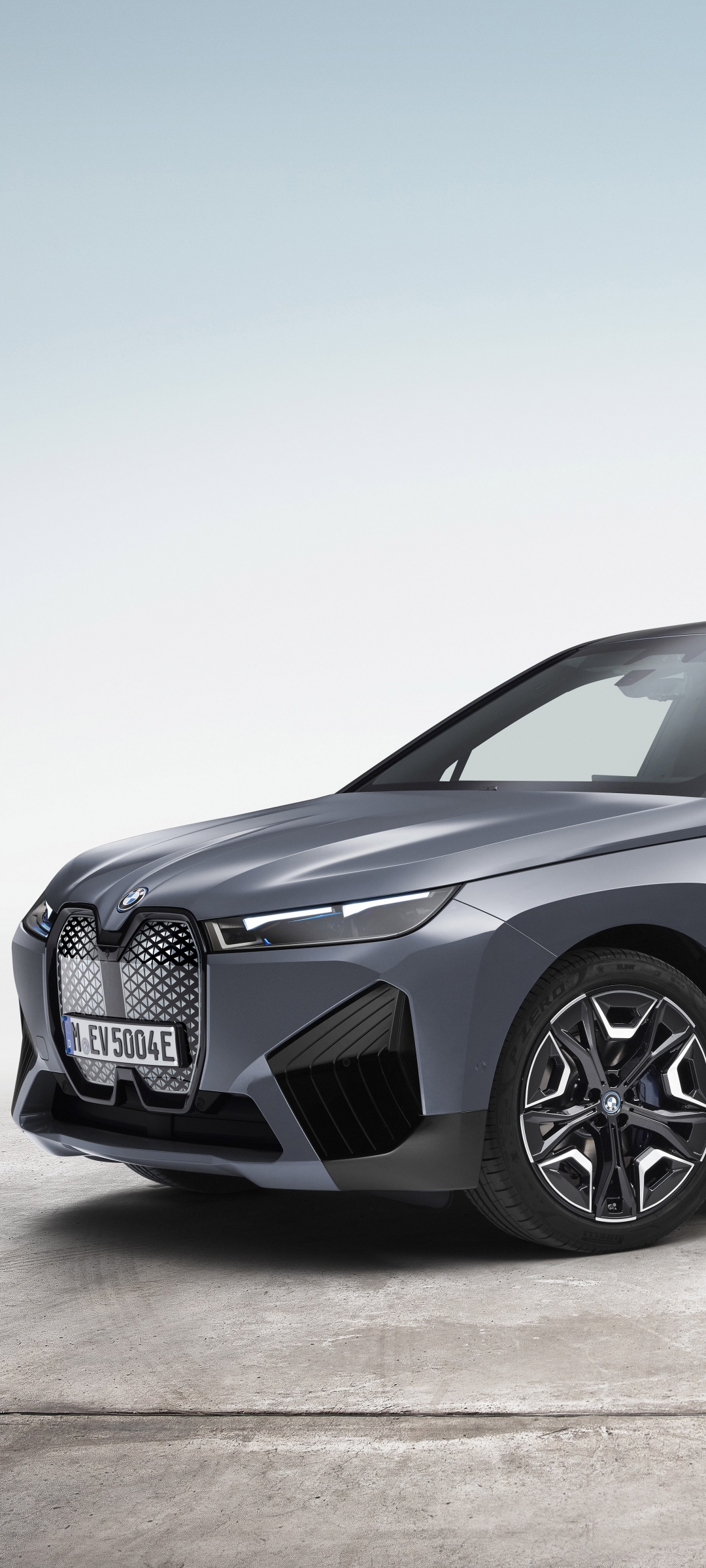 Close-up front view of a sleek, gray BMW iX electric SUV, highlighting its modern design and signature kidney grille