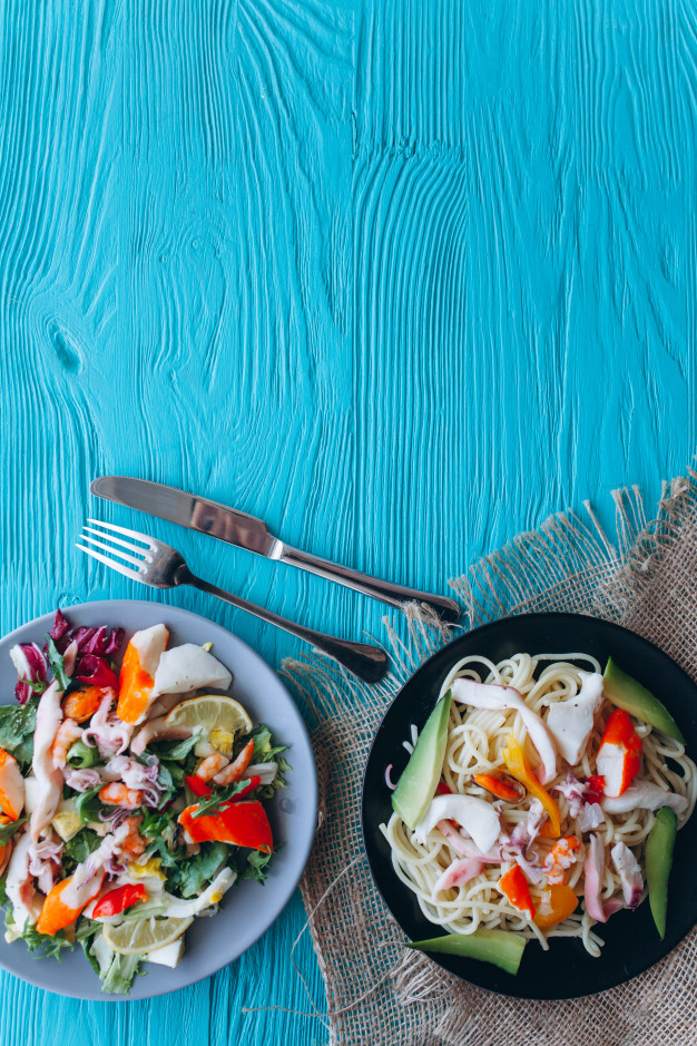 Salad And Pasta With Seafood On A Blue Background Photo Premium