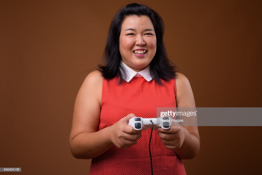 Studio Shot Of Overweight Asian Woman Wearing Red Dress Against