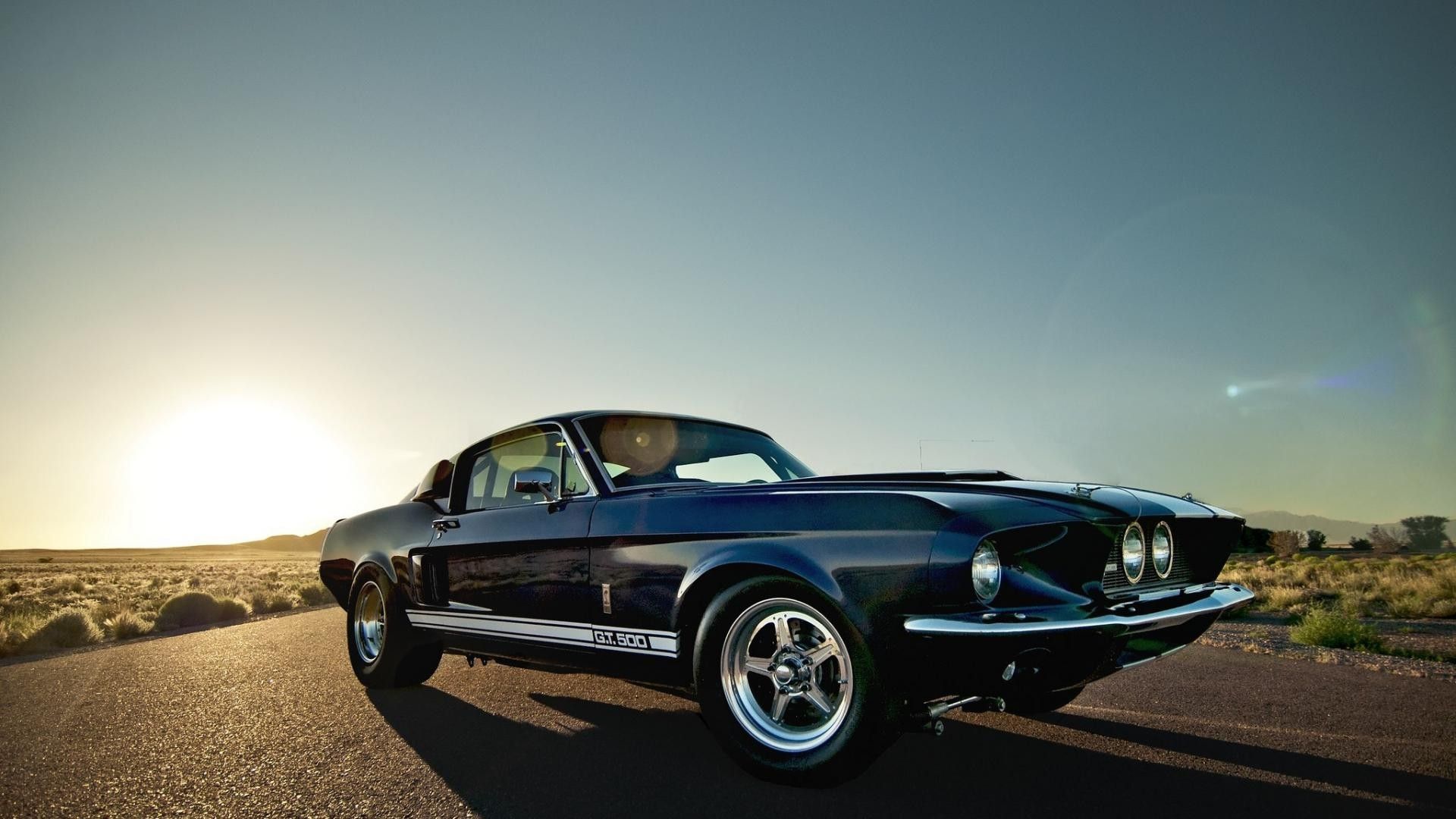 Classic Ford Mustang GT 500 on a desert road at sunset