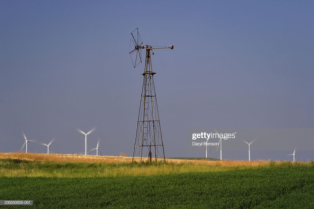 Old Windmill With Modern Wind Turbines In Background Stock Photo