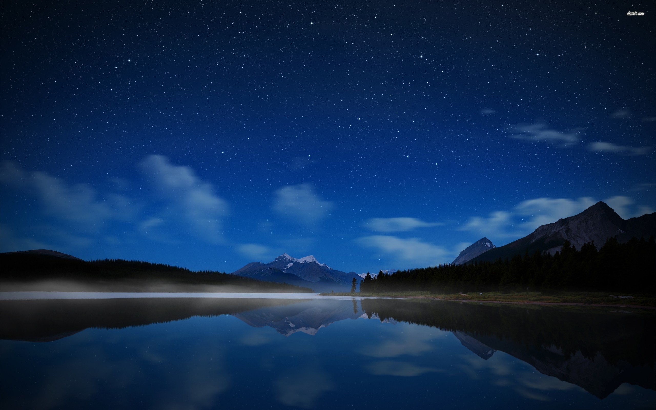 A breathtaking 4K wallpaper showcasing a serene night sky reflected in a still lake, with majestic mountains and a starry backdrop