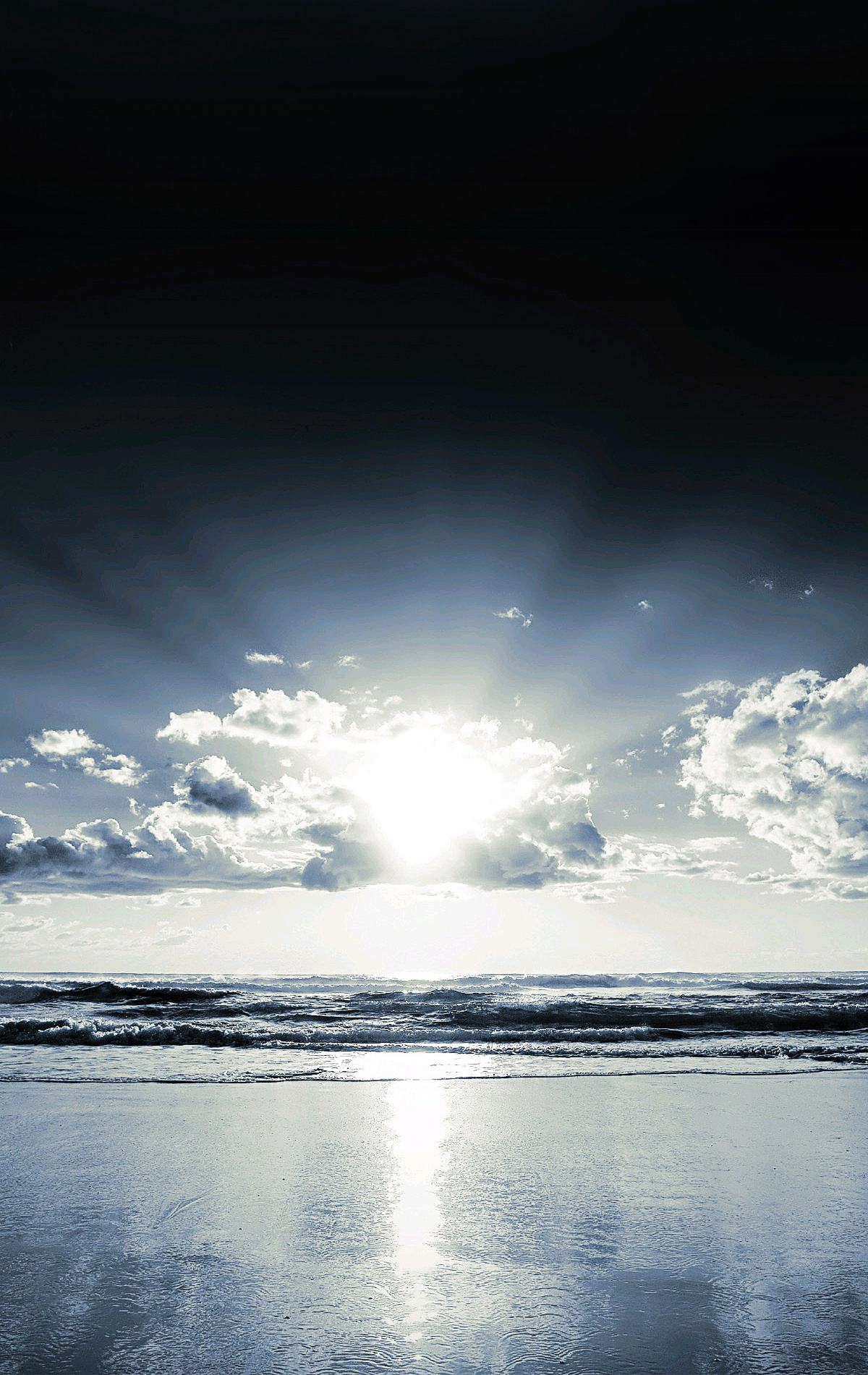 Sun setting across ocean behind glowing clouds extra large image