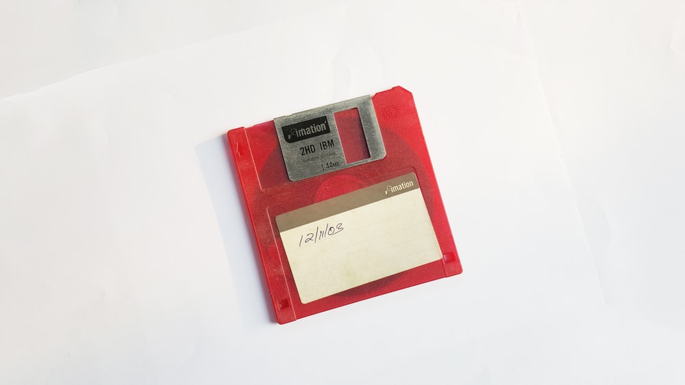 Red And White Floppy Disk On Surface Photo Image