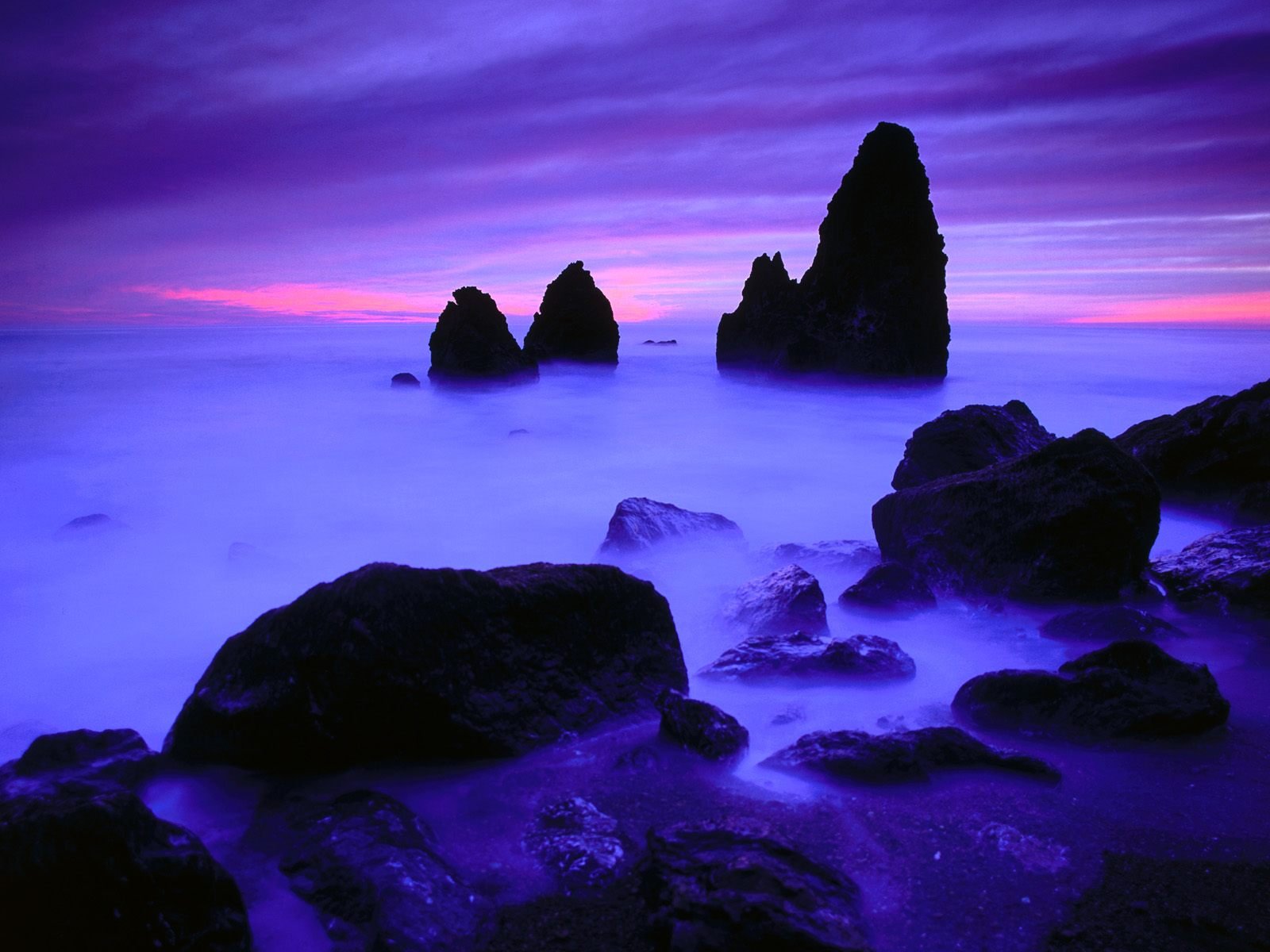 Silhouette of Rocks in Ocean at Twilight