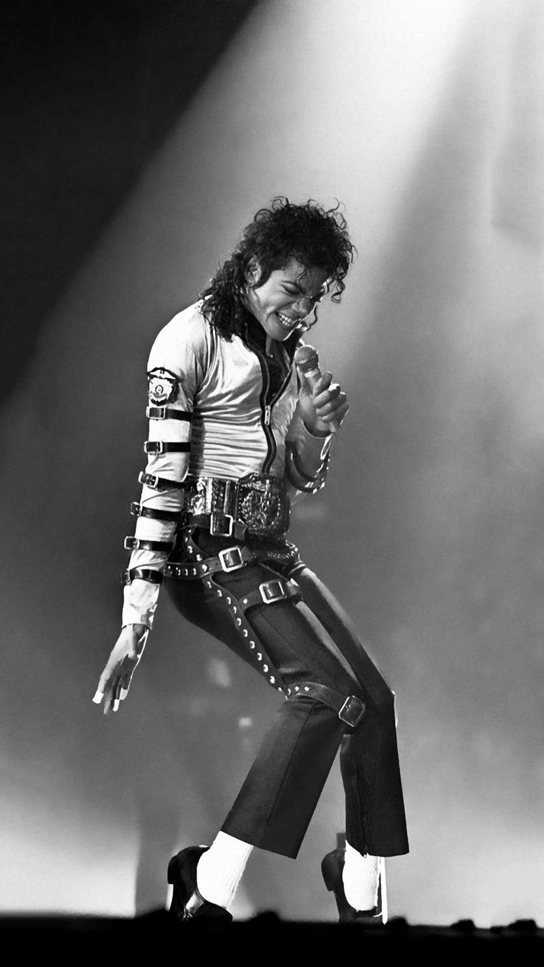 Michael Jackson performing on stage, wearing his iconic studded jacket and pants
