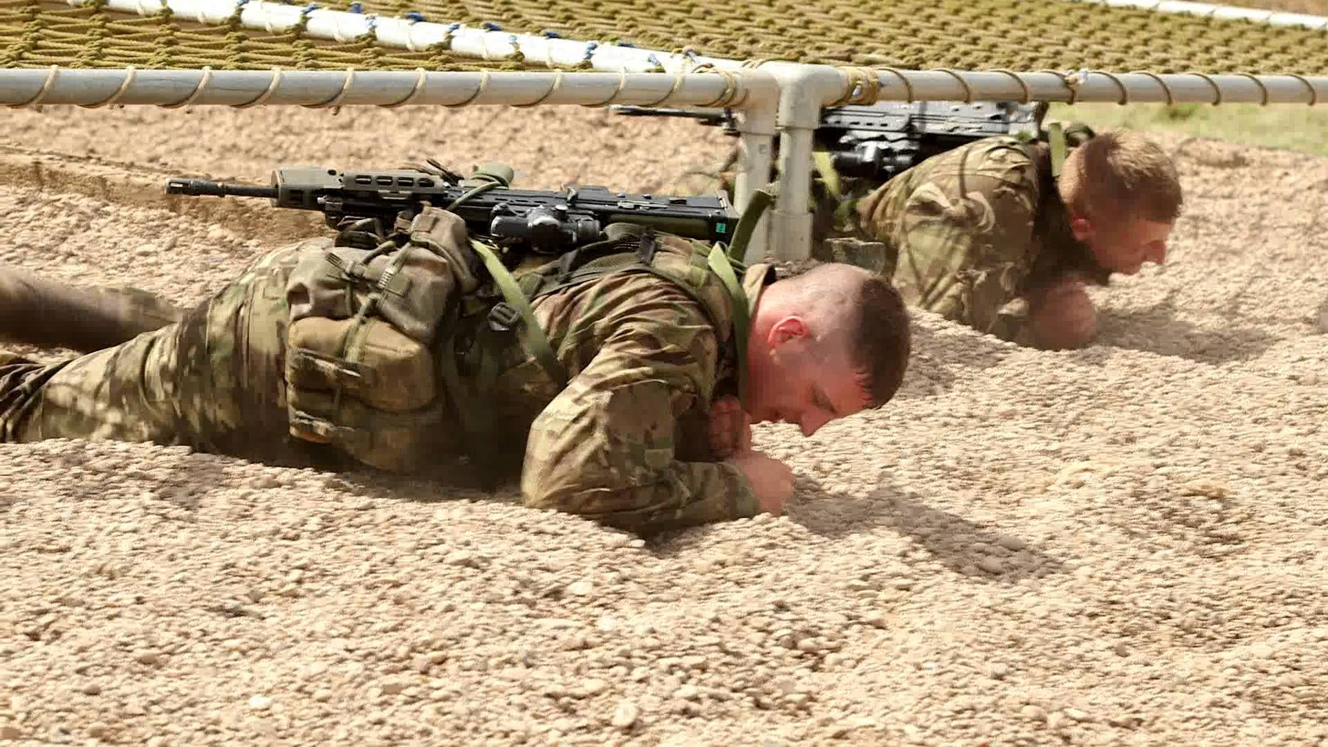 Two French Commandos Marine low-crawling under a net during a training exercise