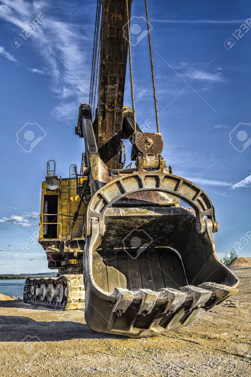 Old Yellow Excavator On The Background Of Blue Sky Stock Photo