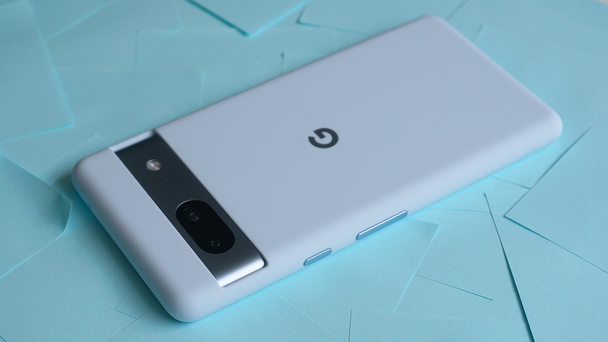 A Google Pixel phone in a light blue case rests on a background of scattered light blue sticky notes