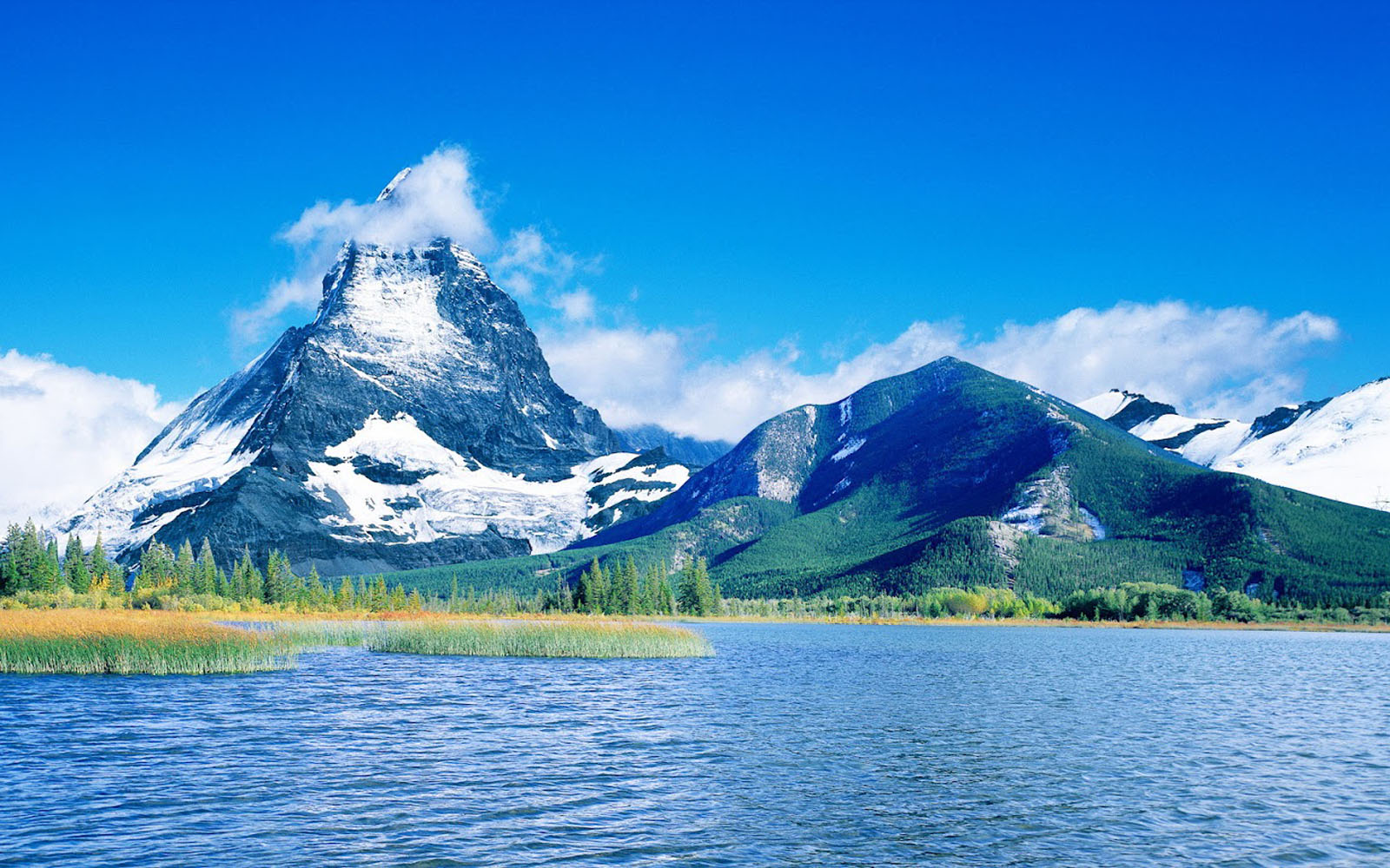 Scenic landscape with snow-capped mountains and a serene lake