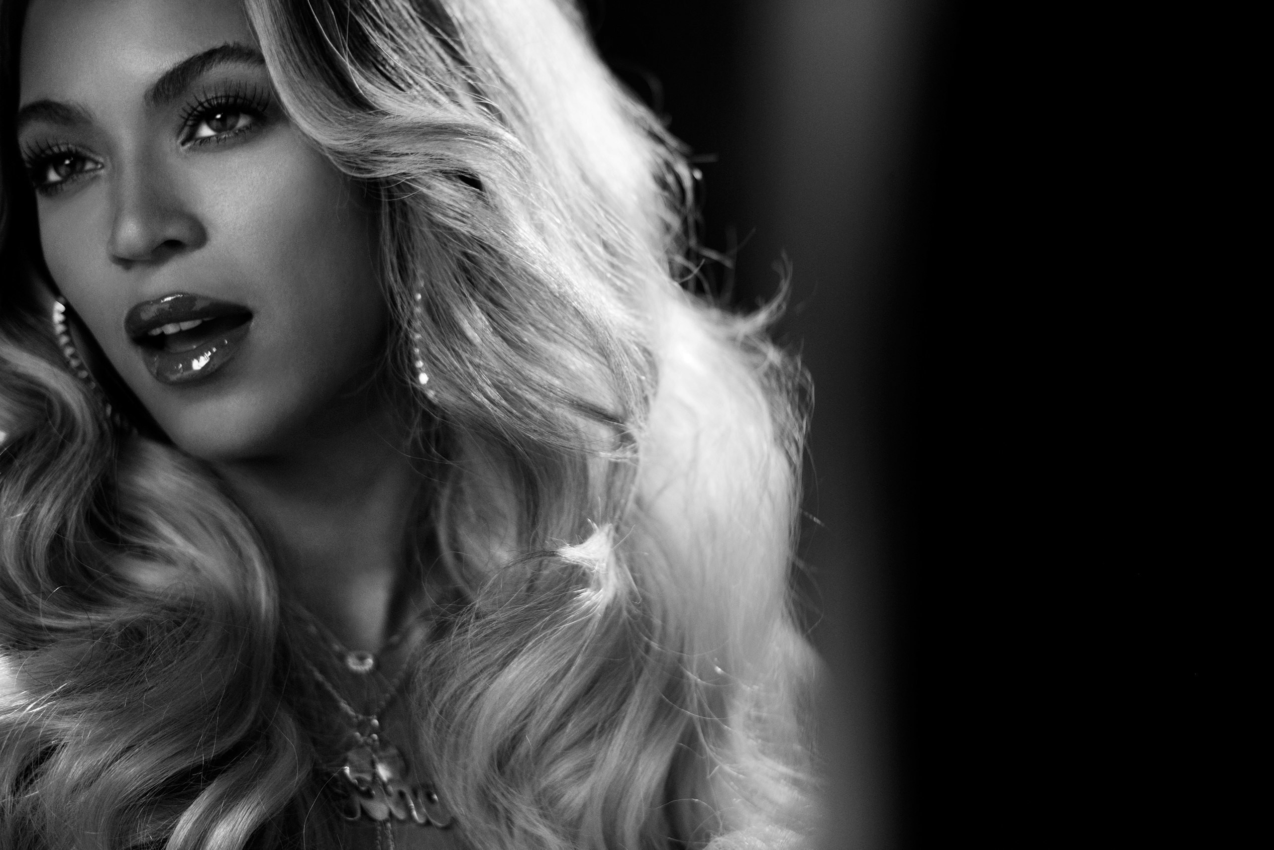 Black and white close-up of Beyoncé, highlighting her glamorous look and flowing hair