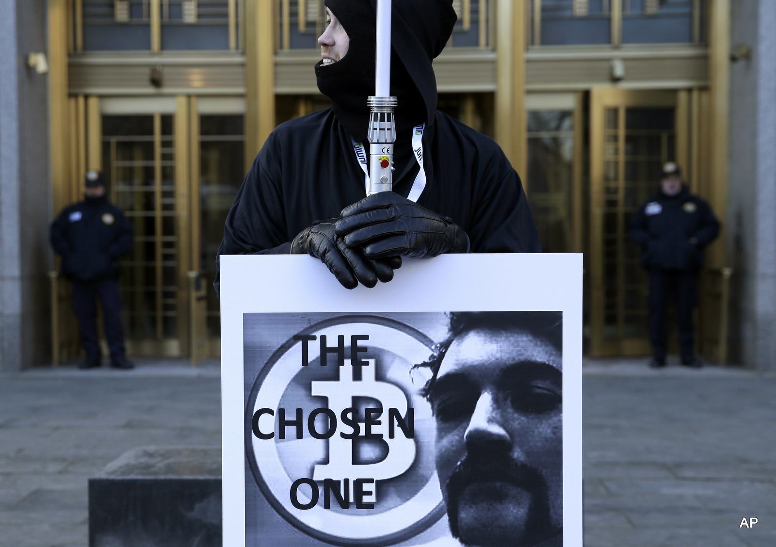 A supporter of Ross Ulbricht, the founder of the Silk Road darknet market, holds a sign with his image and the words 