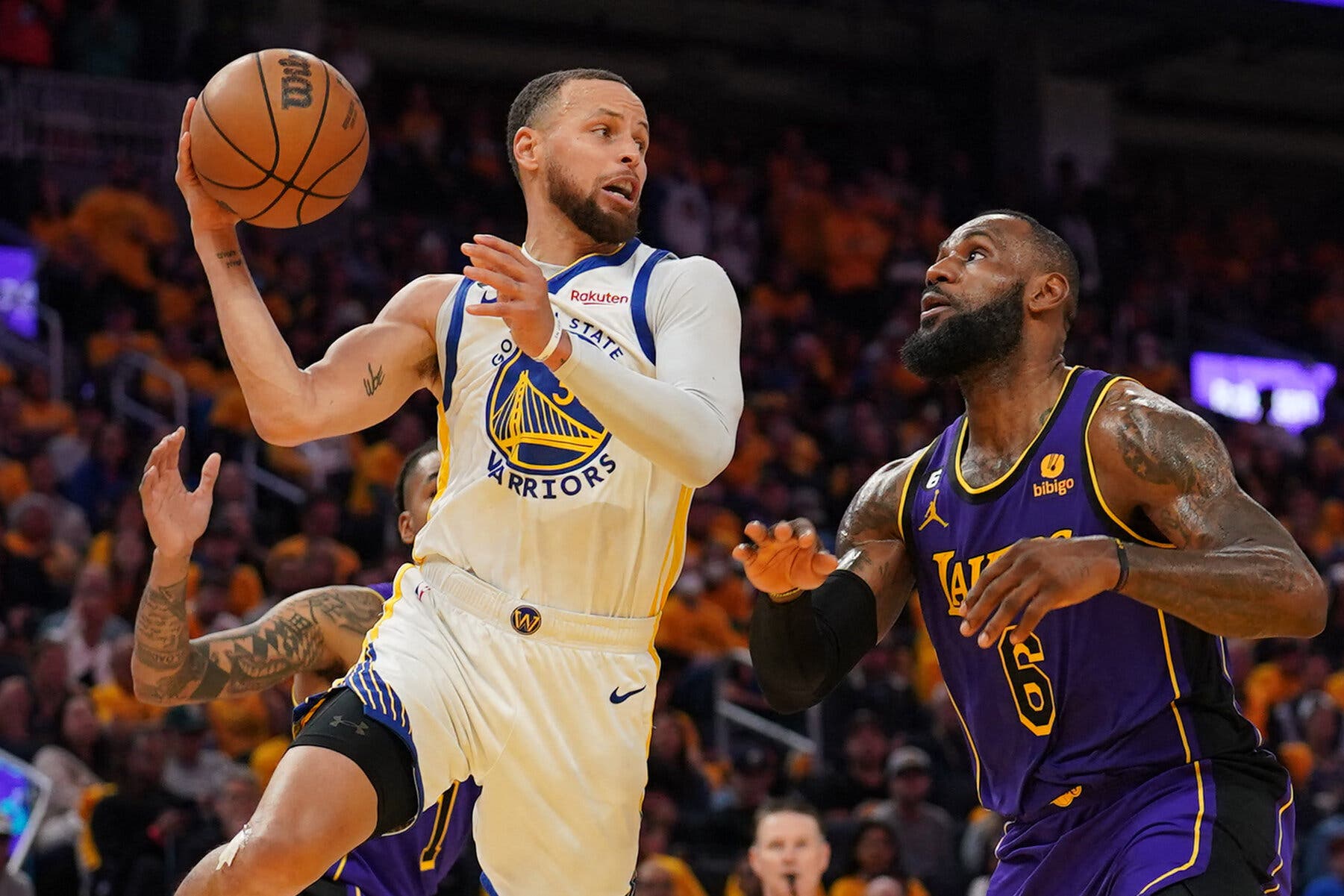 Stephen Curry of the Golden State Warriors drives to the basket while being defended by LeBron James of the Los Angeles Lakers