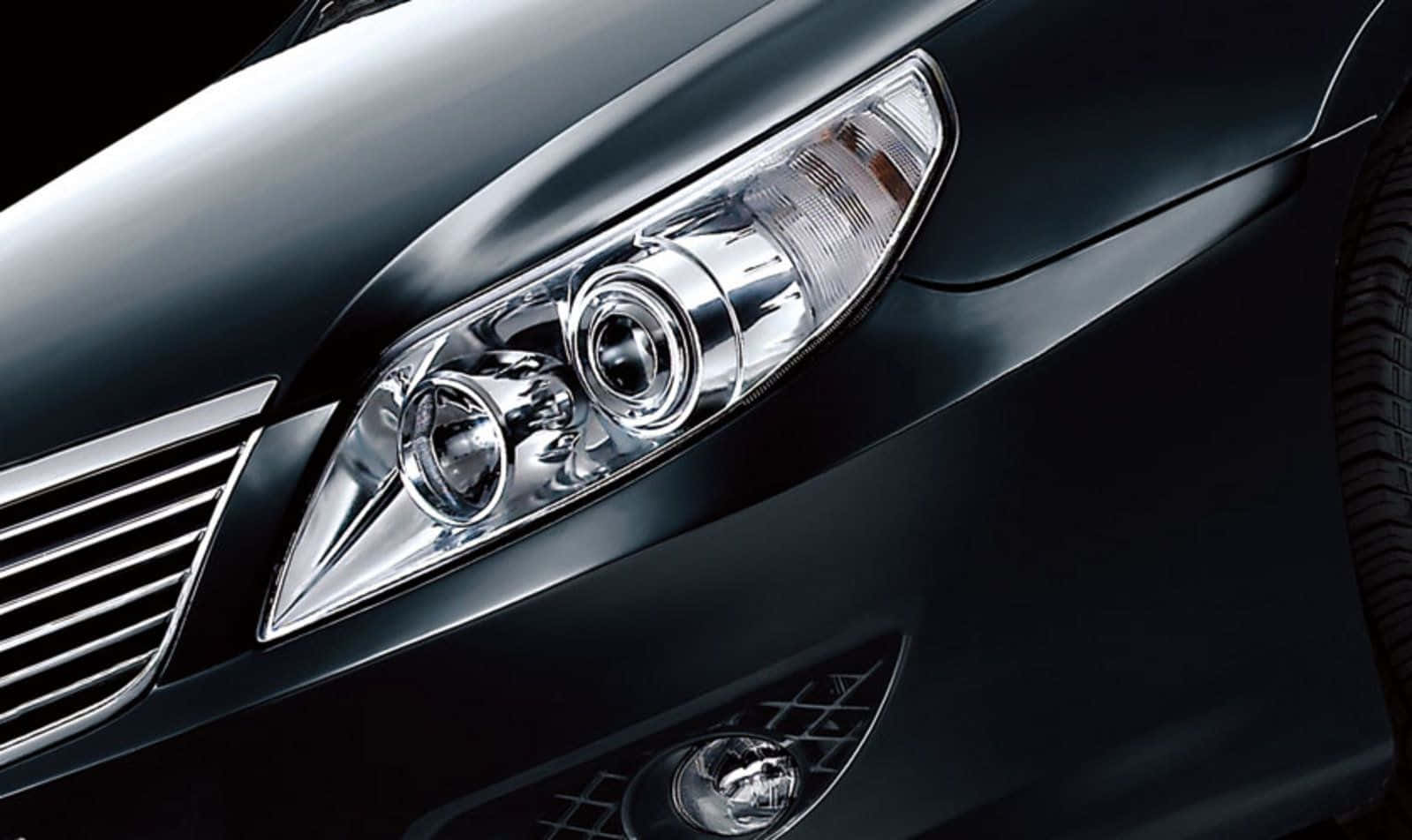 Close-up of a sleek, black BYD car's headlight, showcasing its modern design and polished finish