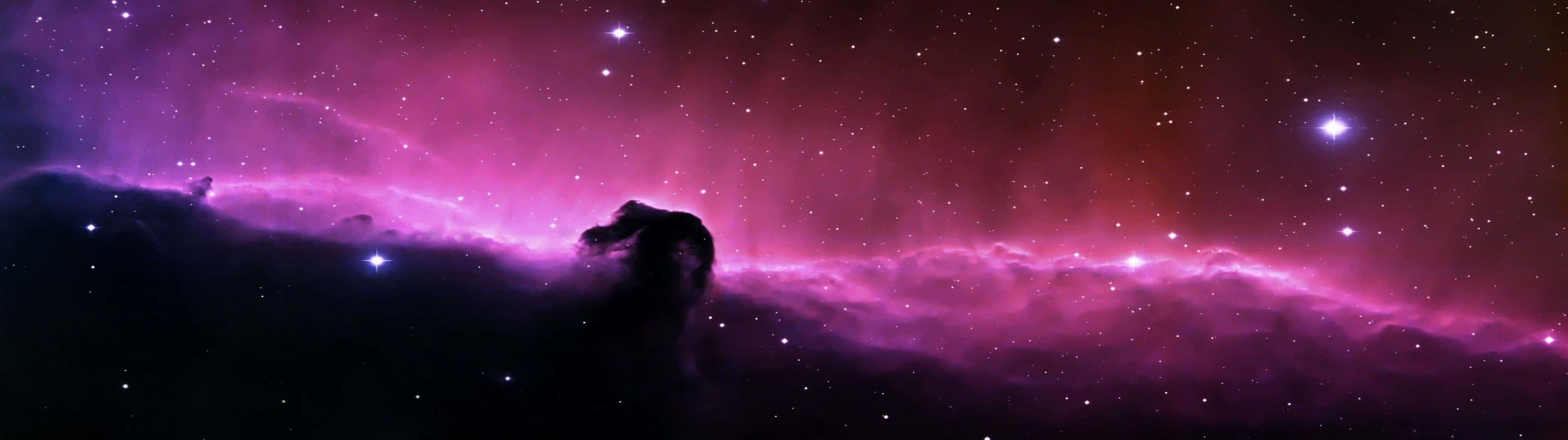 A Purple Nebula With Stars In The Background Wallpaper