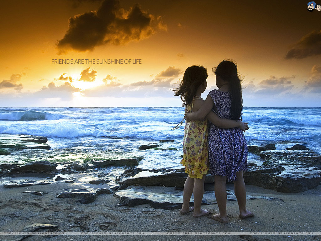Two young friends embracing on a beach at sunset, symbolizing the warmth and joy of friendship
