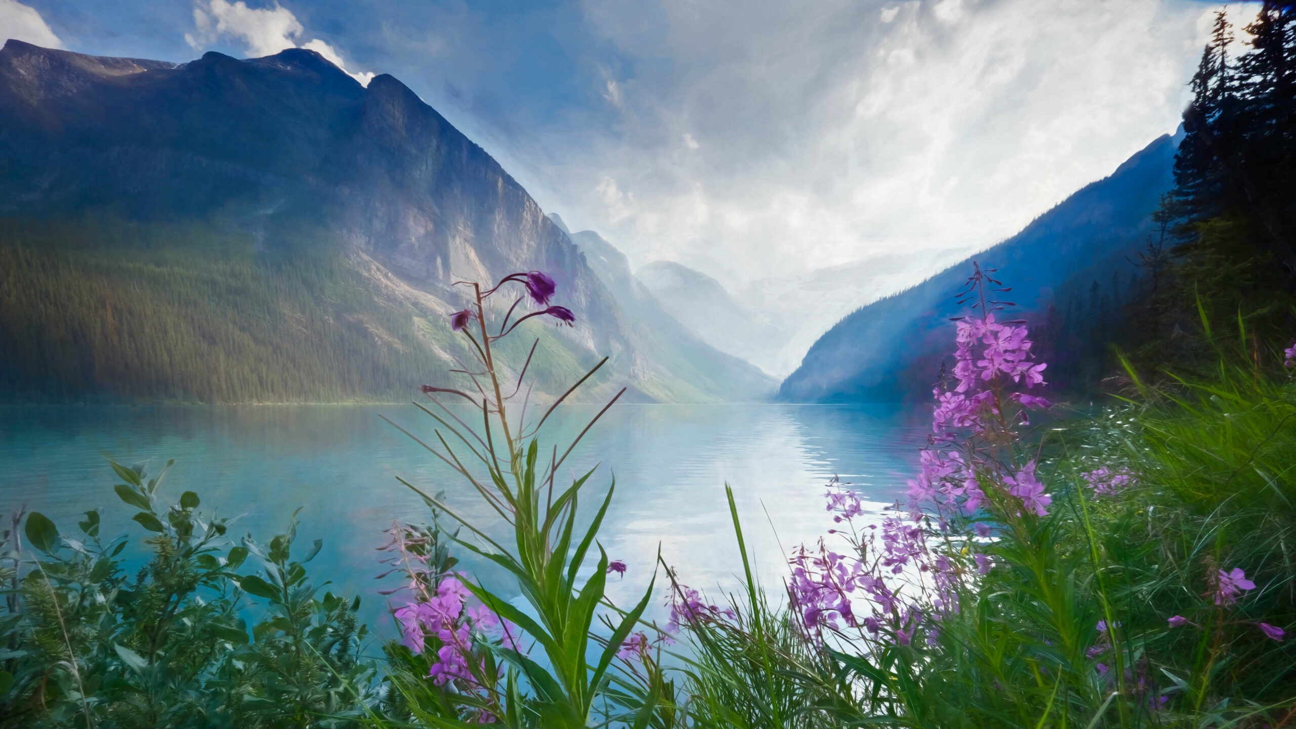 Scenic view of a turquoise lake nestled amidst majestic mountains, with vibrant purple wildflowers in the foreground