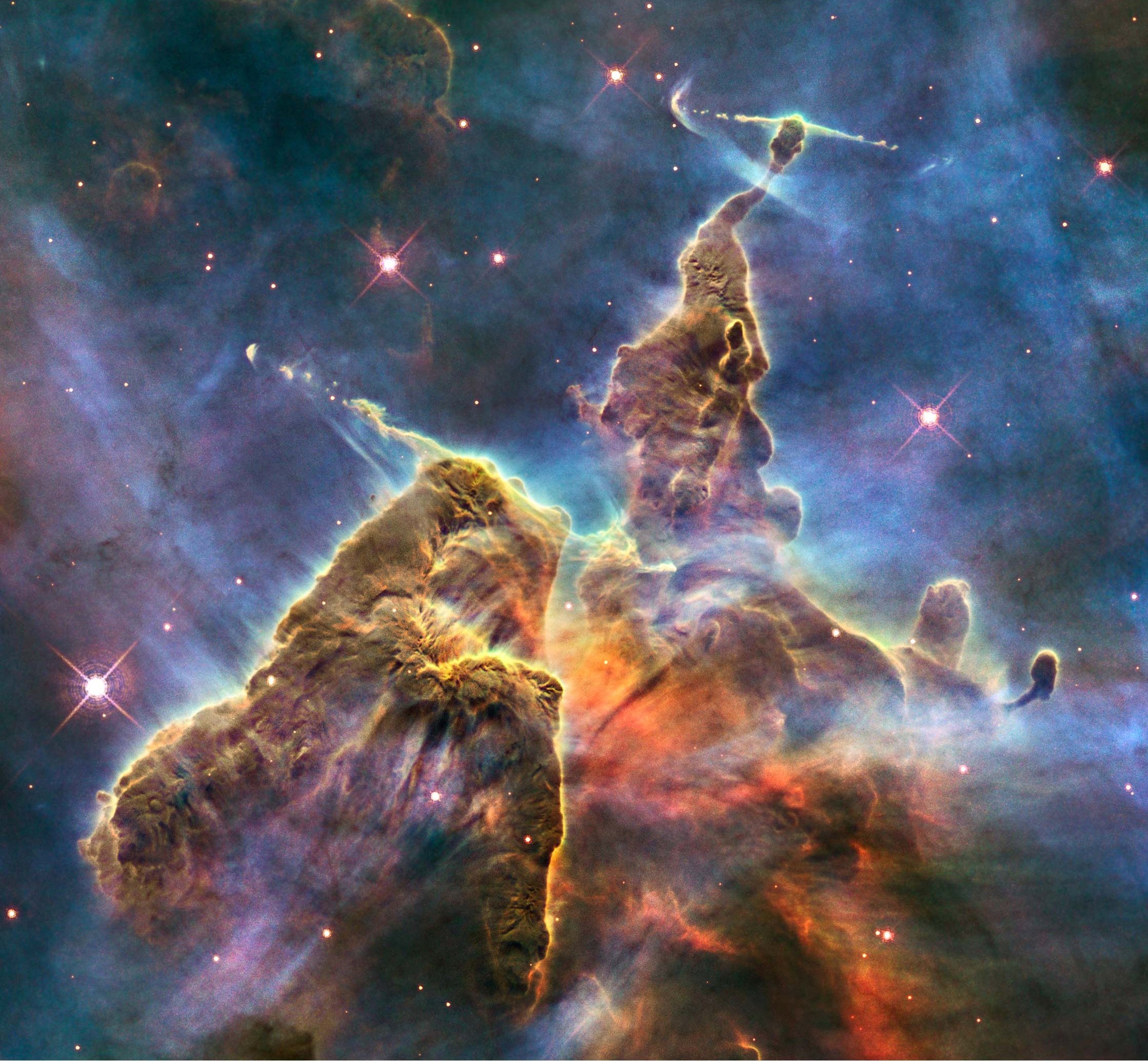 Close-up view of the Pillars of Creation in the Eagle Nebula, showcasing its colorful interstellar gas and dust clouds where new stars are born