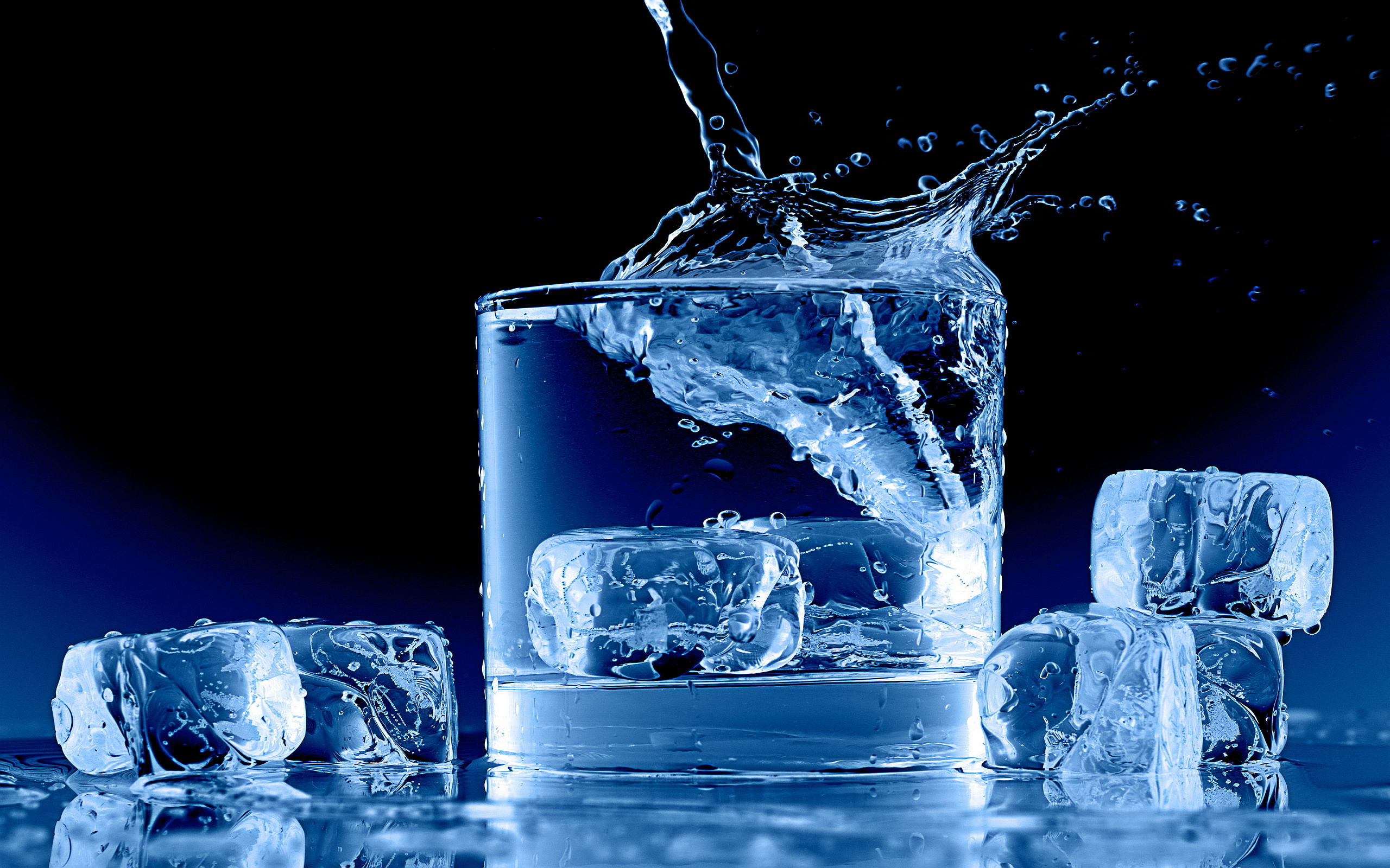 Close-up of a glass of ice water with splashing water and ice cubes