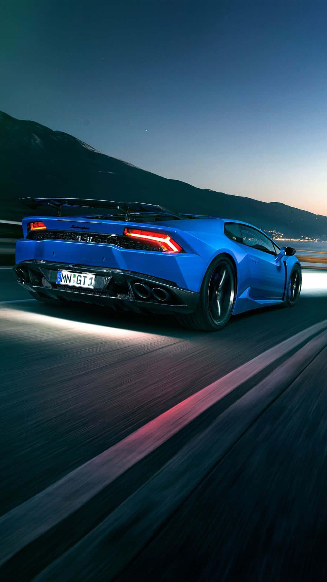 The Blue Lamborghini Huracan Is Driving Down Road At