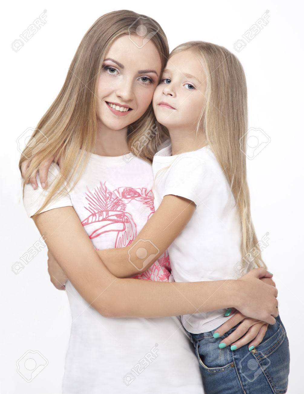 Two Sisters Embrace Isolated On A White Background Stock Photo