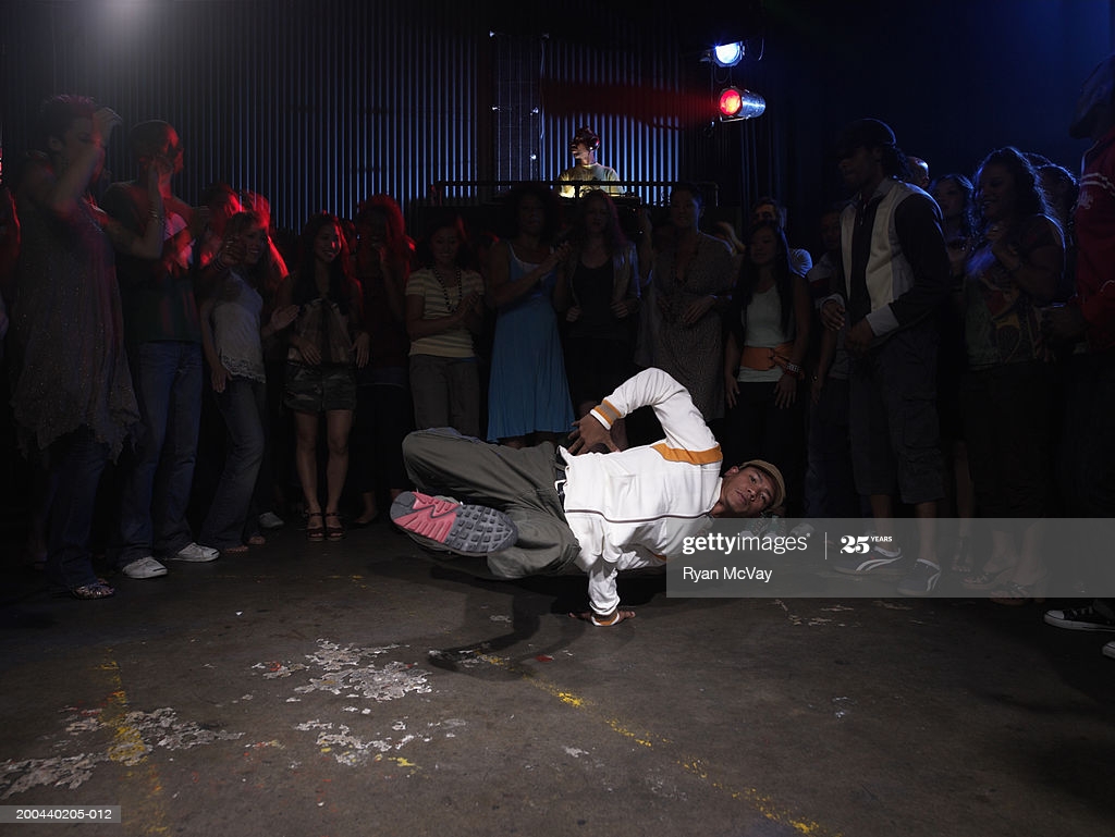 Group Of Adults Watching Man Breakdance In Club Dj Background