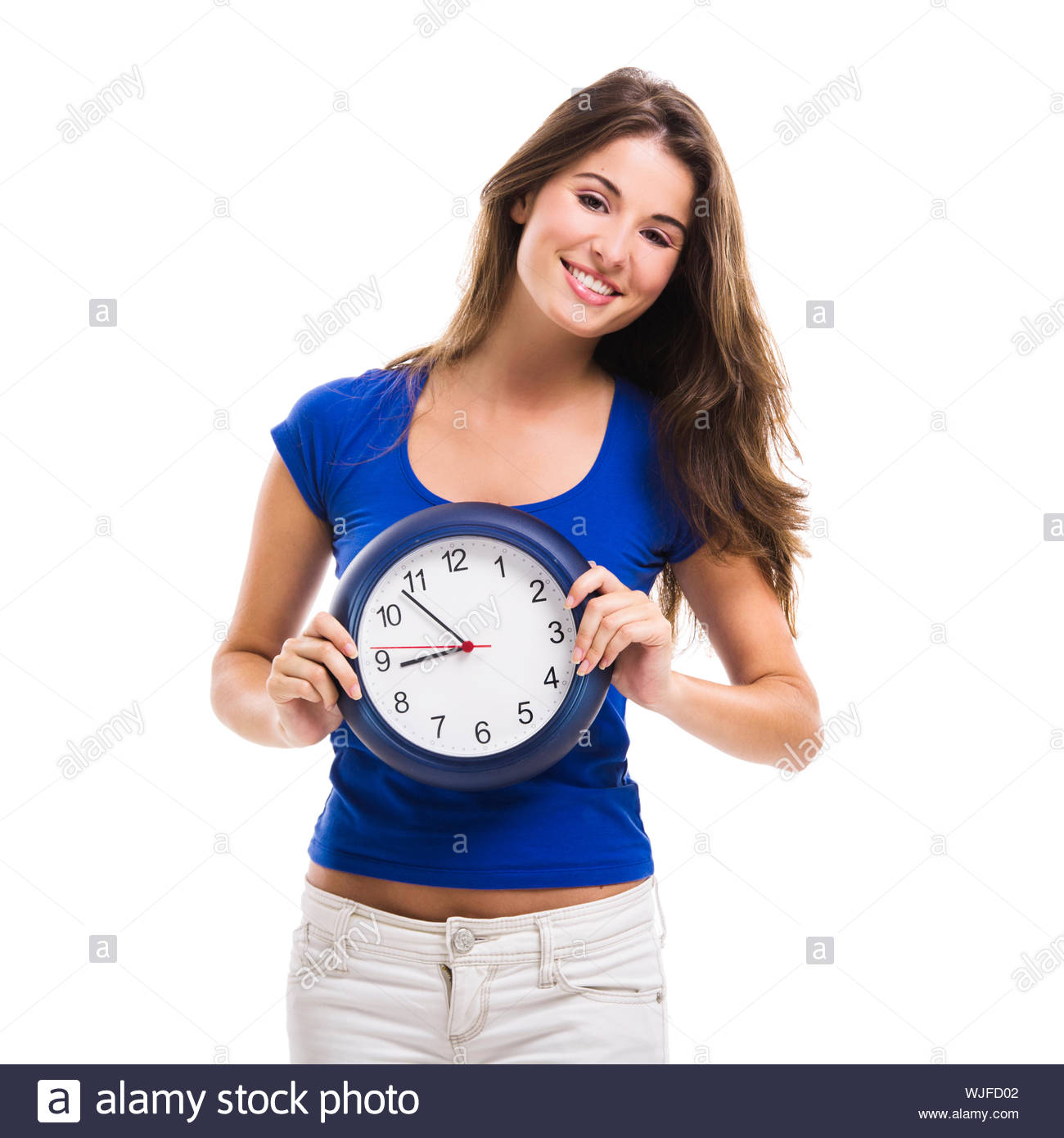 Causal Young Woman Holding A Clock Isolated Over White