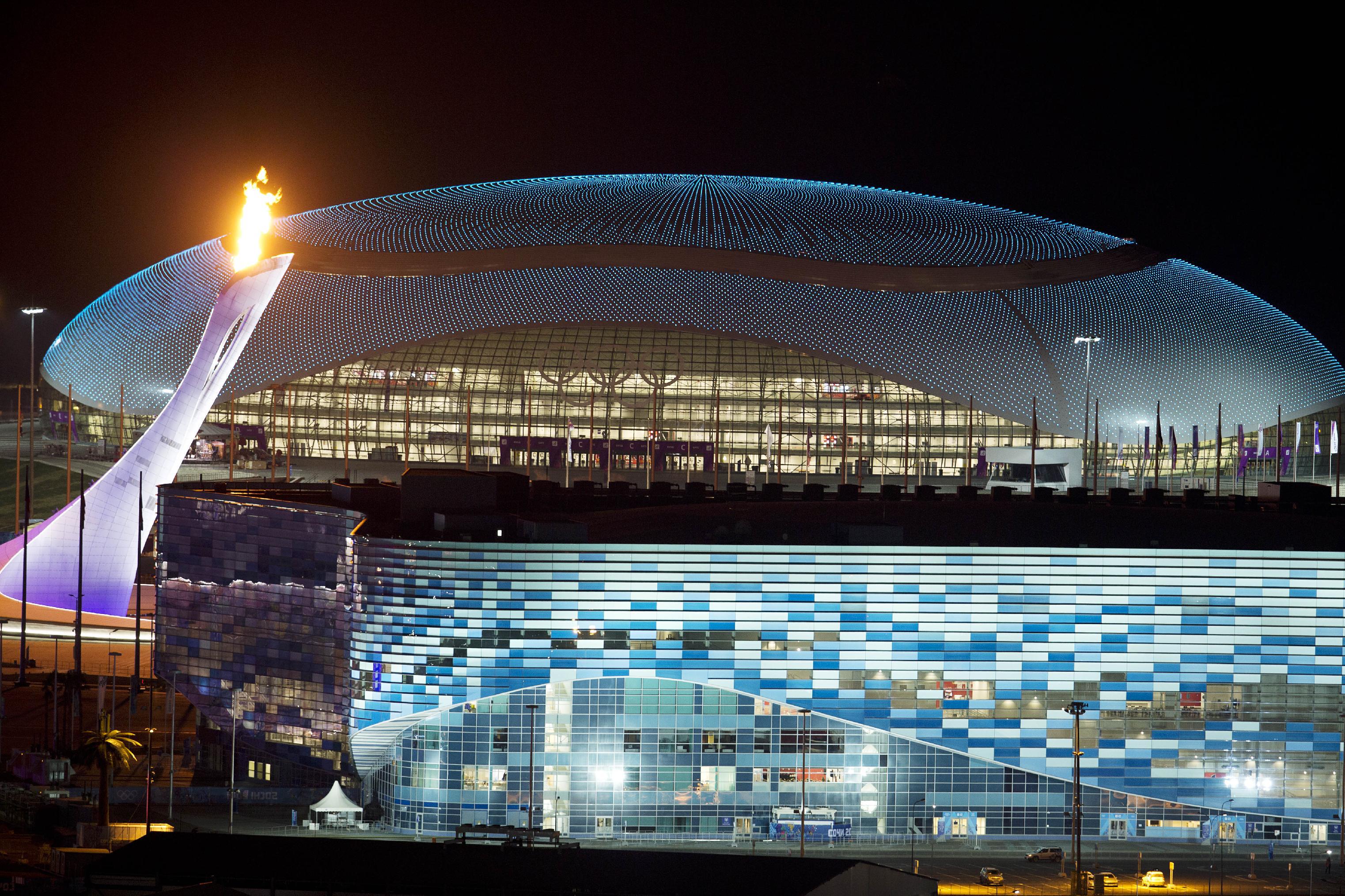 Olympic Torch On A Background Of The Stadium At
