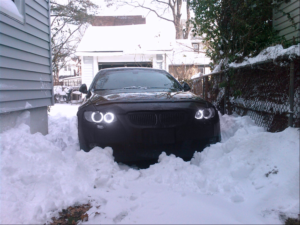 Black BMW car parked in deep snow, showcasing winter driving and snowy weather conditions
