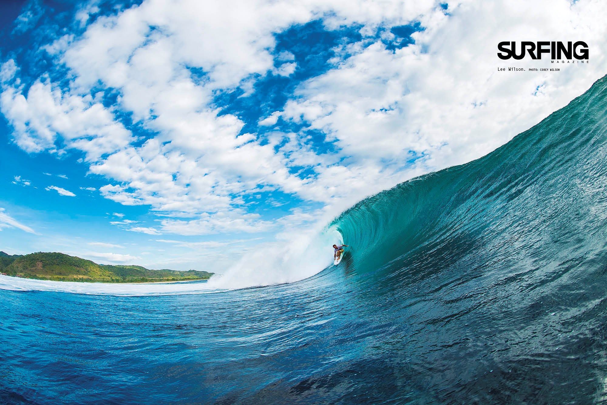 A surfer rides a powerful turquoise wave in a tropical paradise, showcasing the thrill and beauty of surfing