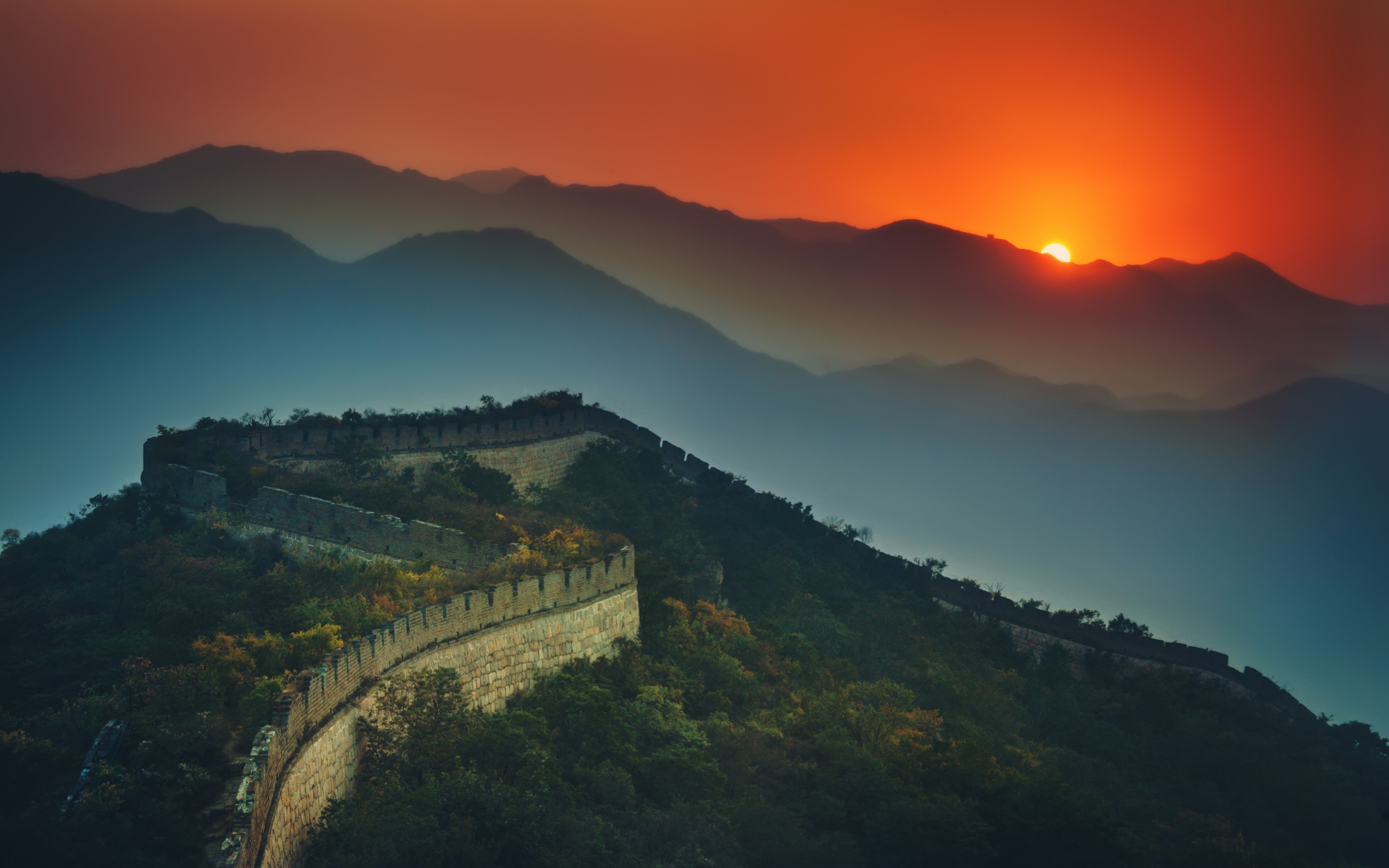 Sunrise over the Great Wall of China, a majestic ancient wonder snaking through the mountains