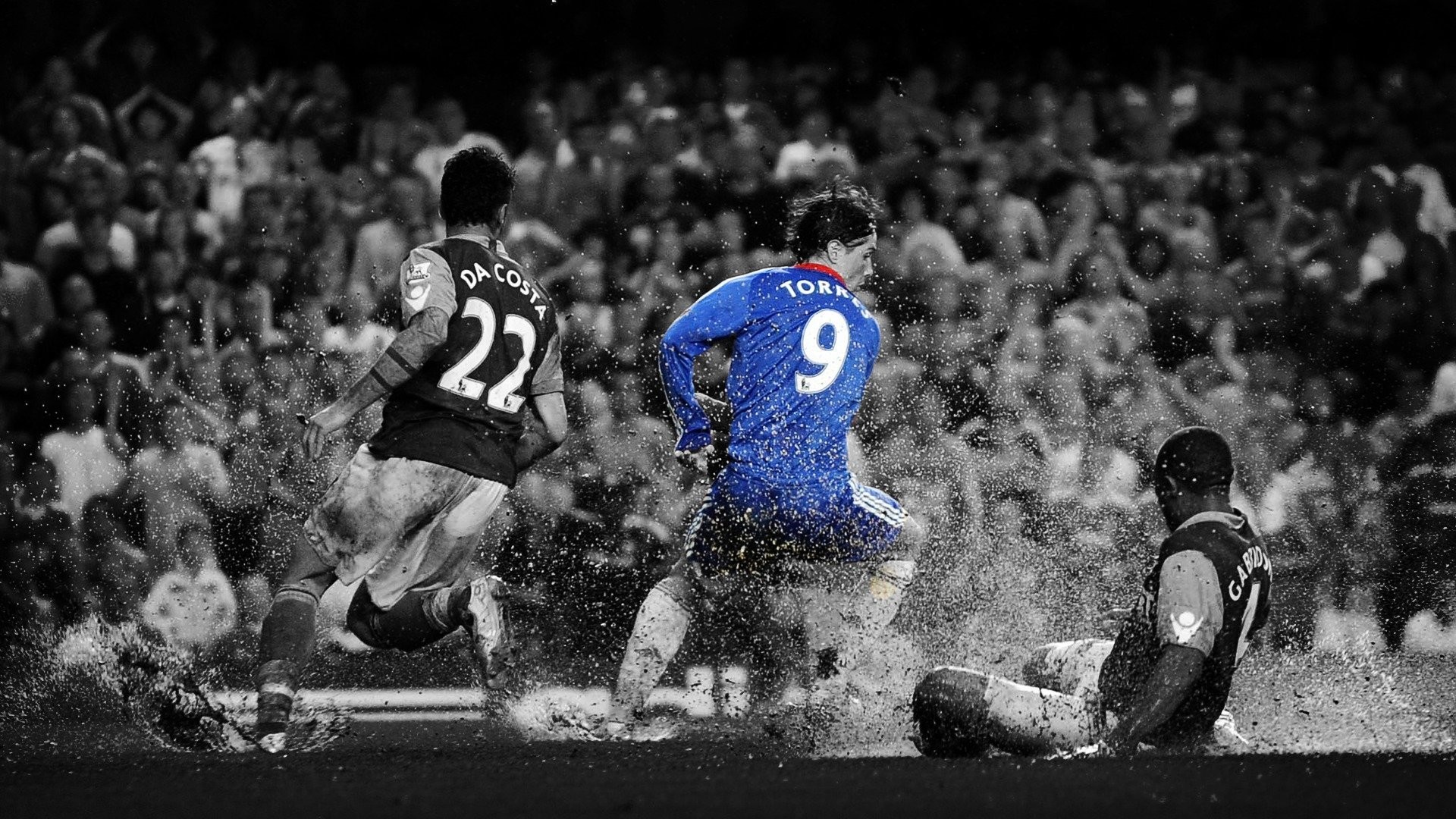 A dramatic black and white image of a Premier League football match, capturing a dynamic moment with players challenging for the ball amidst splashing water