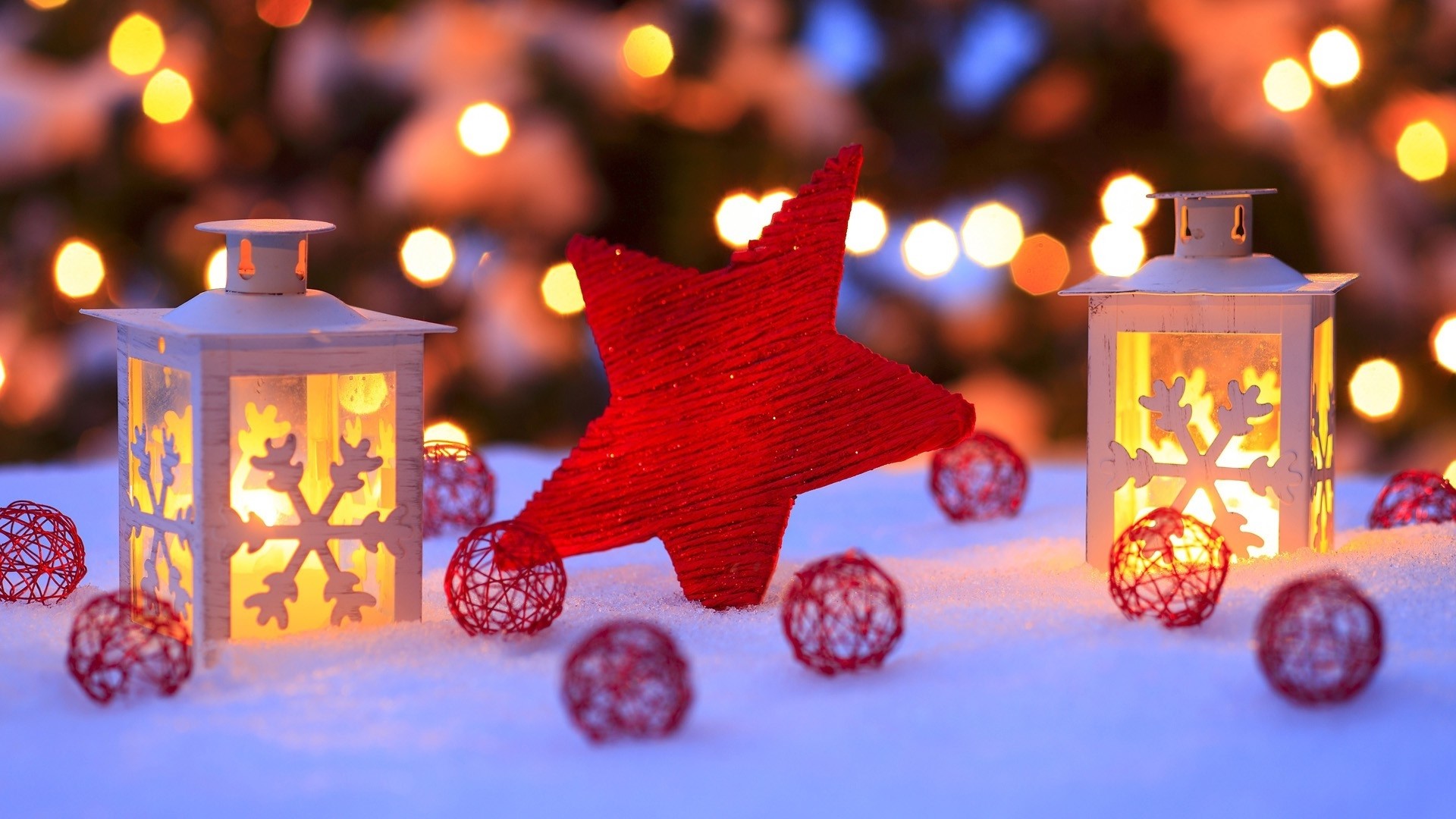 Christmas scene with lanterns, red star, and decorative ornaments on snow, with Christmas lights blurred in the background