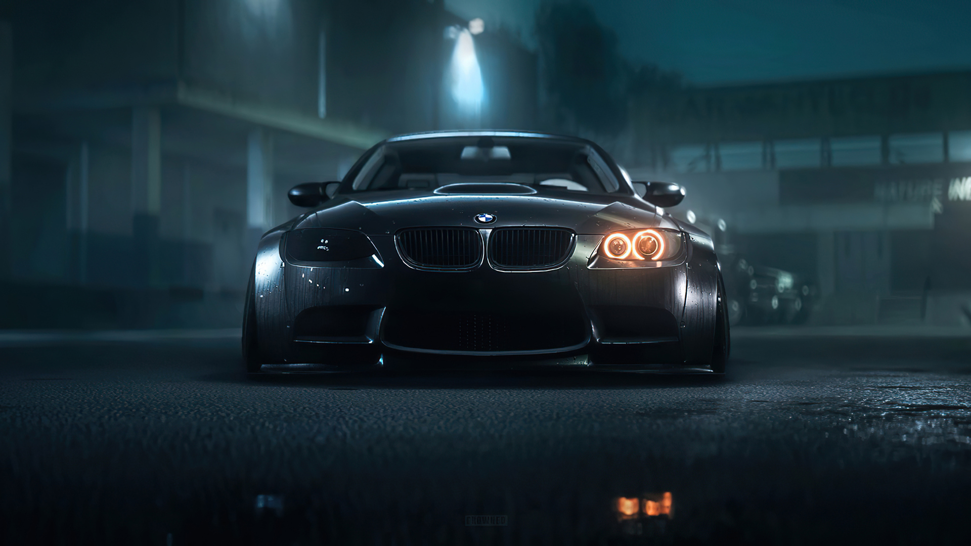 A sleek, black BMW sports car parked on a dark, wet street at night, with its headlights glowing