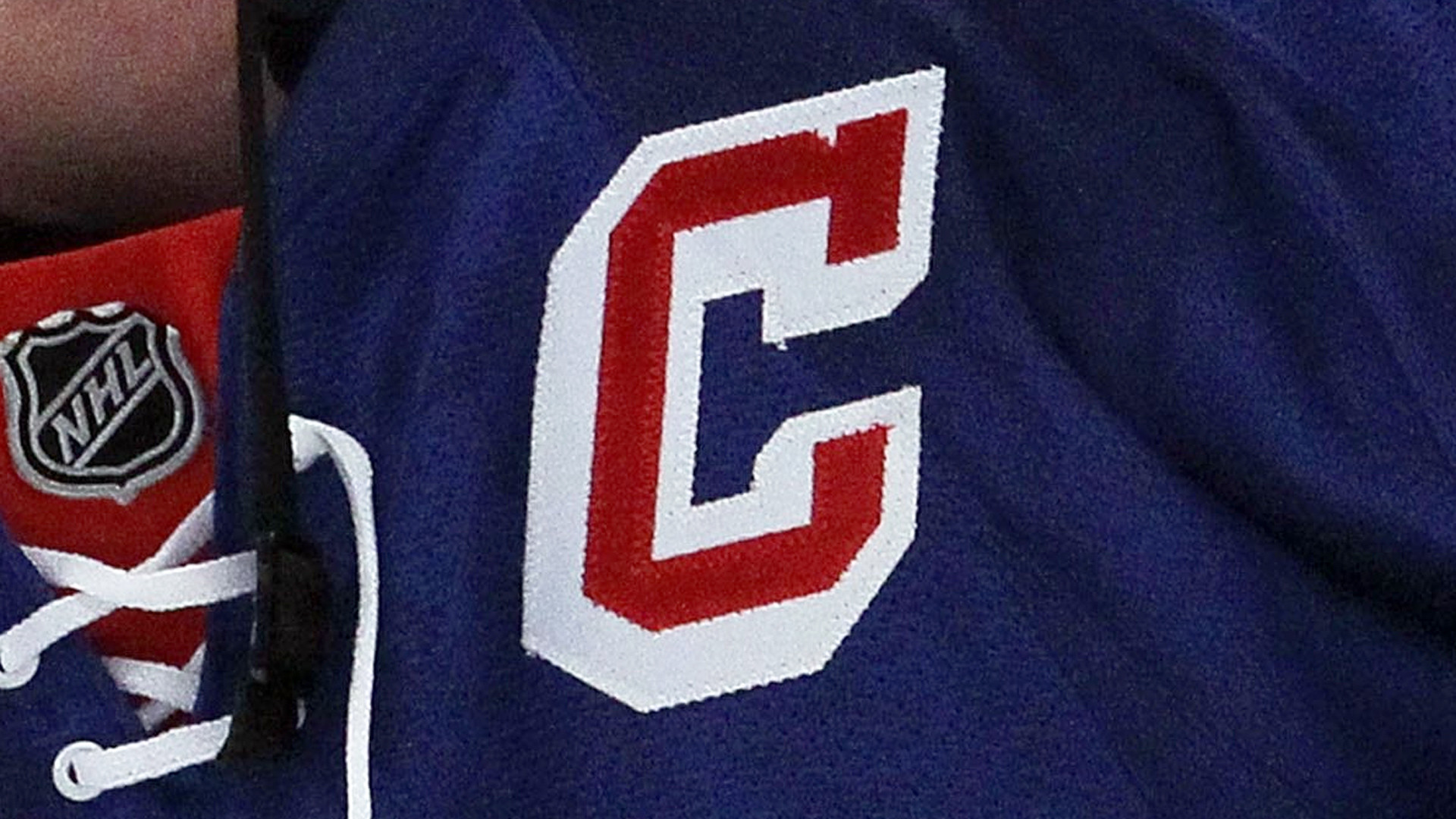 Close-up of the New York Rangers 'C' logo on a blue jersey