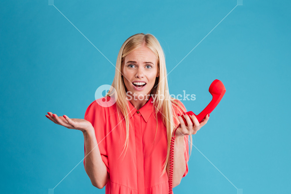 Puzzled Worried Young Blonde Woman Standing And Talking On Retro