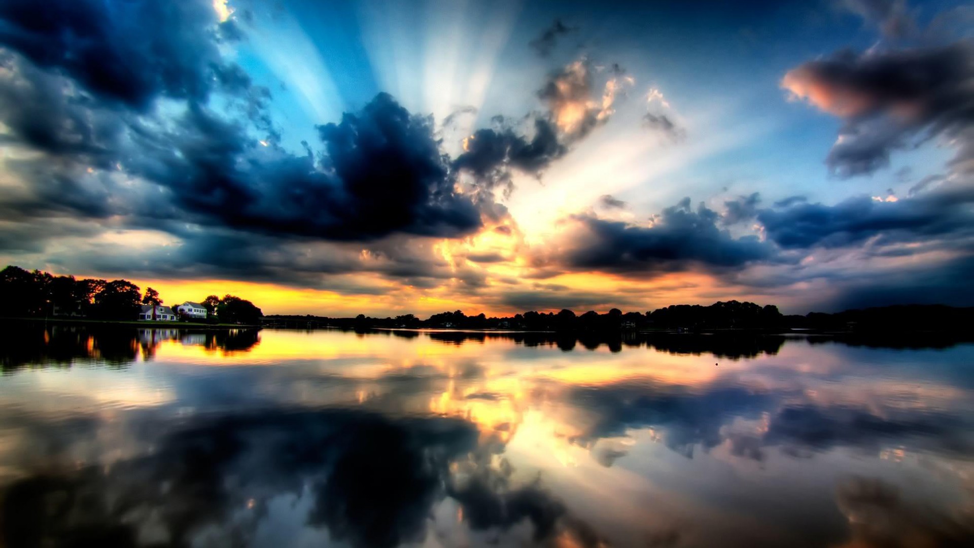Stunning sunset reflected in a calm lake with dramatic clouds and sun rays
