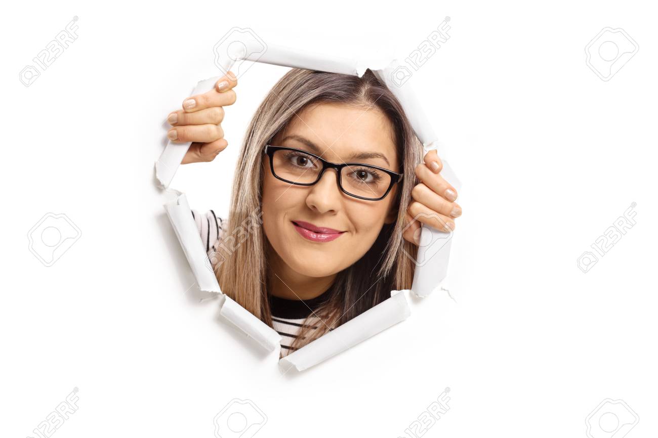 Young Woman Peeping Through A Paper Hole Isolated On White