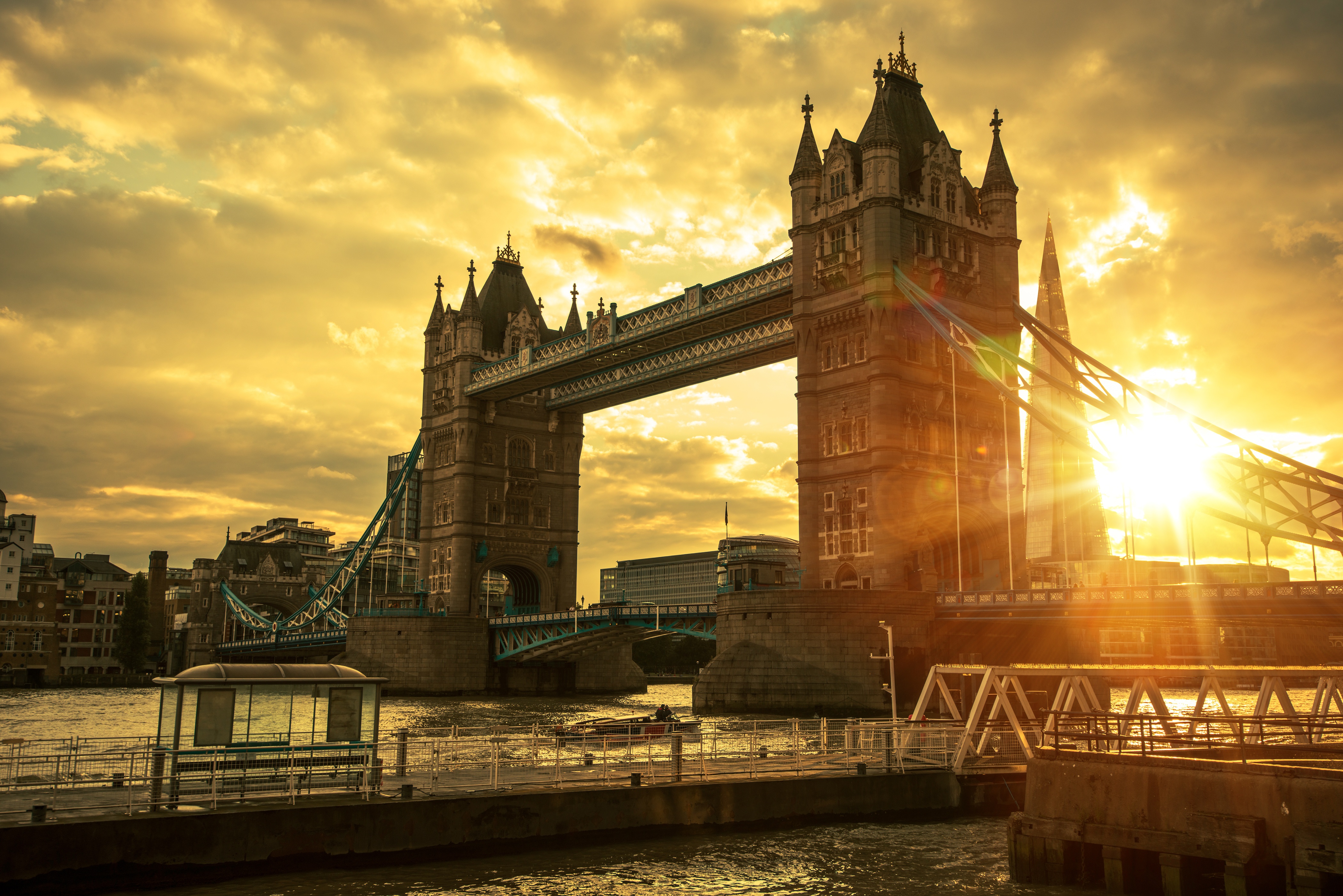 Tower Bridge in London at sunset, with golden light reflecting on the Thames River