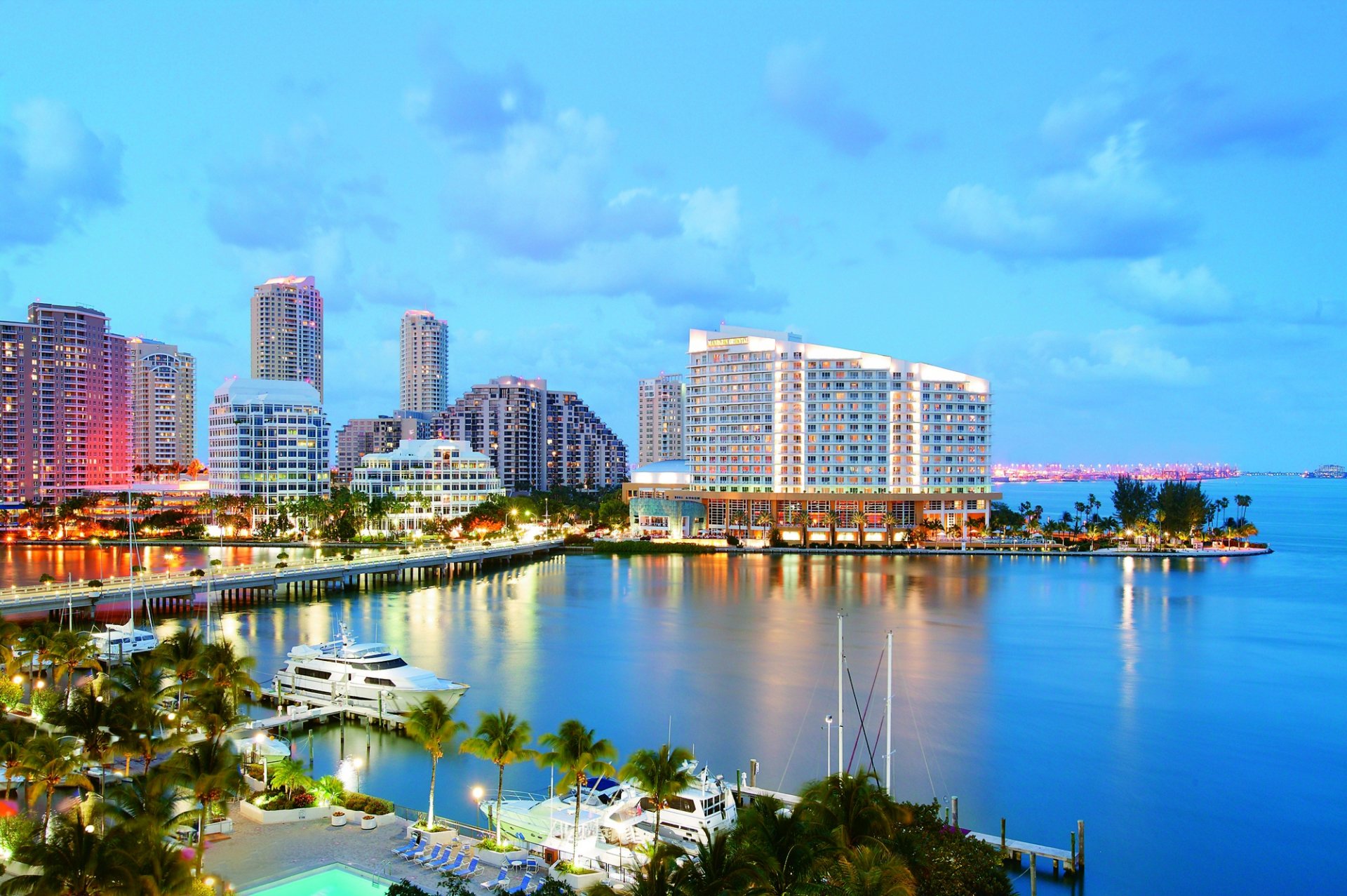 Miami skyline at dusk with illuminated buildings and calm waterfront